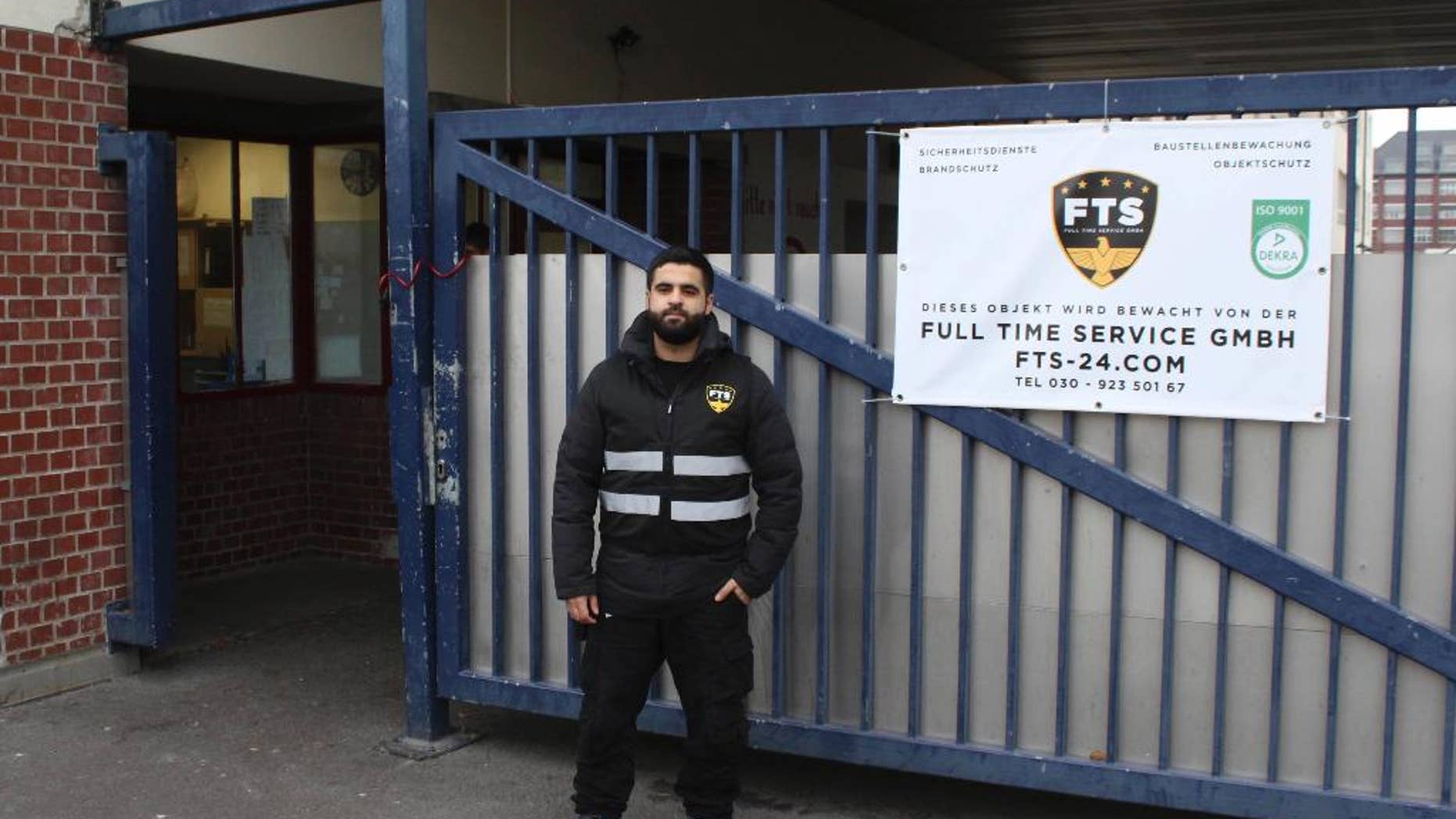 In this Oct. 19, 2016 photo Naji Negmah, a 24-year old asylum seeker from Damascus, stands in front of an asylum seeker home in Berlin where he works as a guard. A start-up company in Berlin is trying to play a role in helping integrate last year's flood of migrants into the German workforce with a tailor-made online job market for new arrivals. (AP Photo/Jona Kallgren)