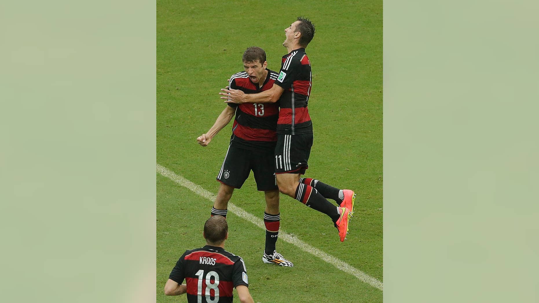 Germany's Thomas Mueller (13) is congratulated by teammates avert he scored during the group G World Cup soccer match between the USA and Germany at the Arena Pernambuco in Recife, Brazil, Thursday, June 26, 2014. (AP Photo/Hassan Ammar)
