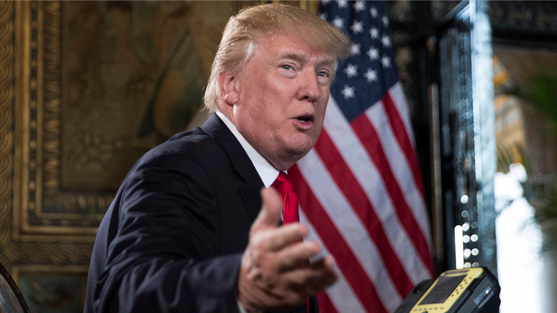 President Donald Trump turns to talk to the gathered media during a Christmas Eve video teleconference with members of the mIlitary at his Mar-a-Lago estate in Palm Beach, Fla., Sunday, Dec. 24, 2017.