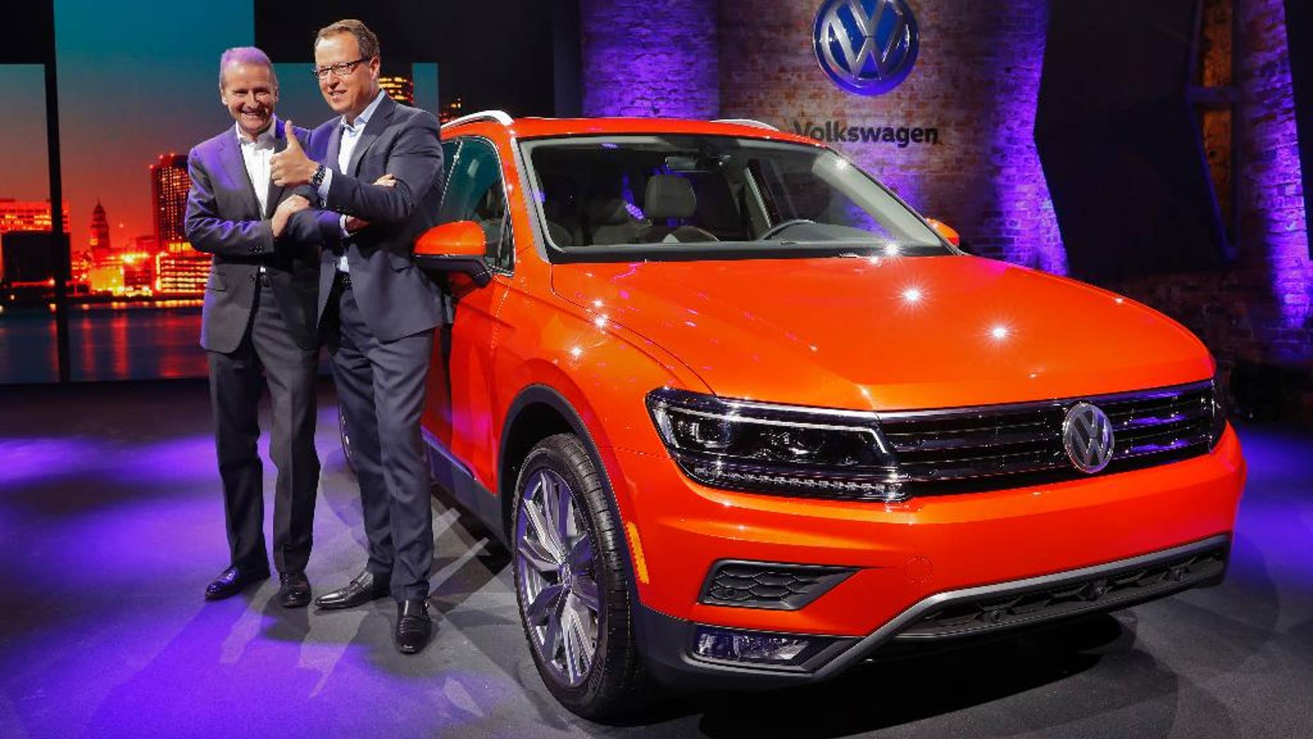 Herbert Diess, left, Member of the Board of Management of Volkswagen AG, Chairman of the Board of Management of the Volkswagen Passenger Cars brand and Hinrich Woebcken, right, CEO of the North America Region, Volkswagen and President and CEO of Volkswagen Group of America, Inc. pose after unveiling the Volkswagen Tiguan before the North American International Auto Show in Detroit, Sunday, Jan. 8, 2017. (AP Photo/Paul Sancya)