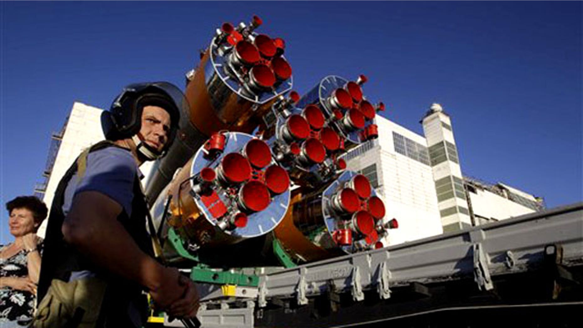 A Russian police officer stands guard as the Russian Soyuz TMA-19 space ship that will carry new crew to the international space station is transported from a hangar to the launch pad at the Russian-leased Baikonur Cosmodrome in Baikonur, Kazakhstan, Sunday, June 13, 2010.