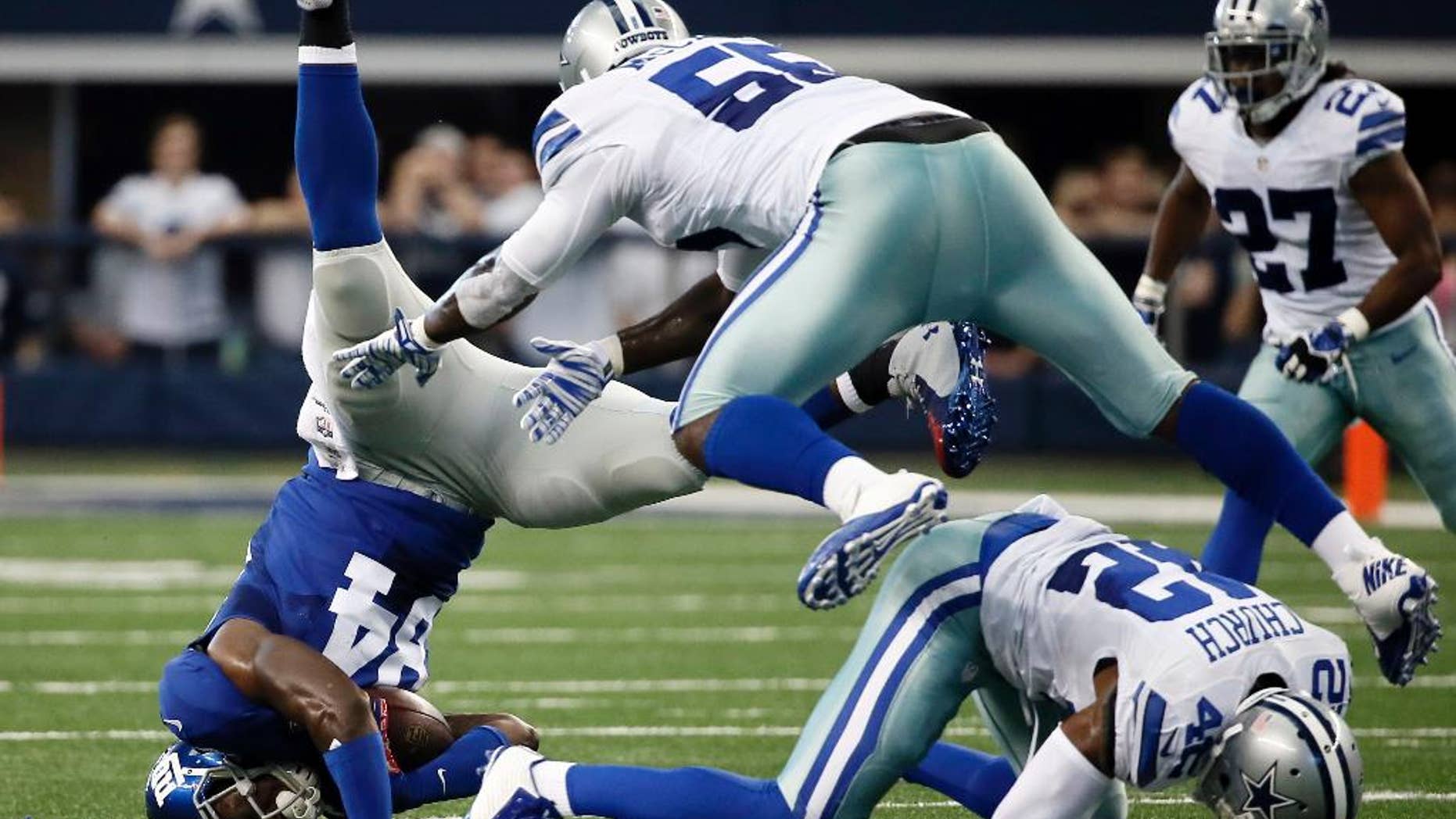 New York Giants tight end Larry Donnell (84) is upended after catching a pass by Dallas Cowboys middle linebacker Rolando McClain (55) and free safety Barry Church (42) during the first half of an NFL football game Sunday, Oct. 19, 2014, in Arlington, Texas. (AP Photo/Brandon Wade)