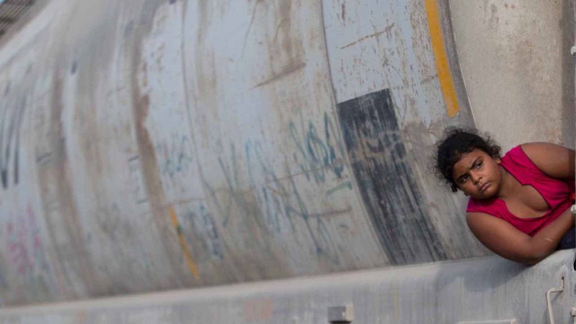 FILE - In this July 12, 2014, file photo, a young migrant girl waits for a freight train to depart on her way to the U.S. border, in Ixtepec, Mexico. In a report released Monday, Aug. 21, 2016, the UN children's agency said that thousands of children trying to escape gang violence and poverty in Central America have made their way to the United States this year and there is no sign that the flow is letting up. (AP Photo/Eduardo Verdugo, File)