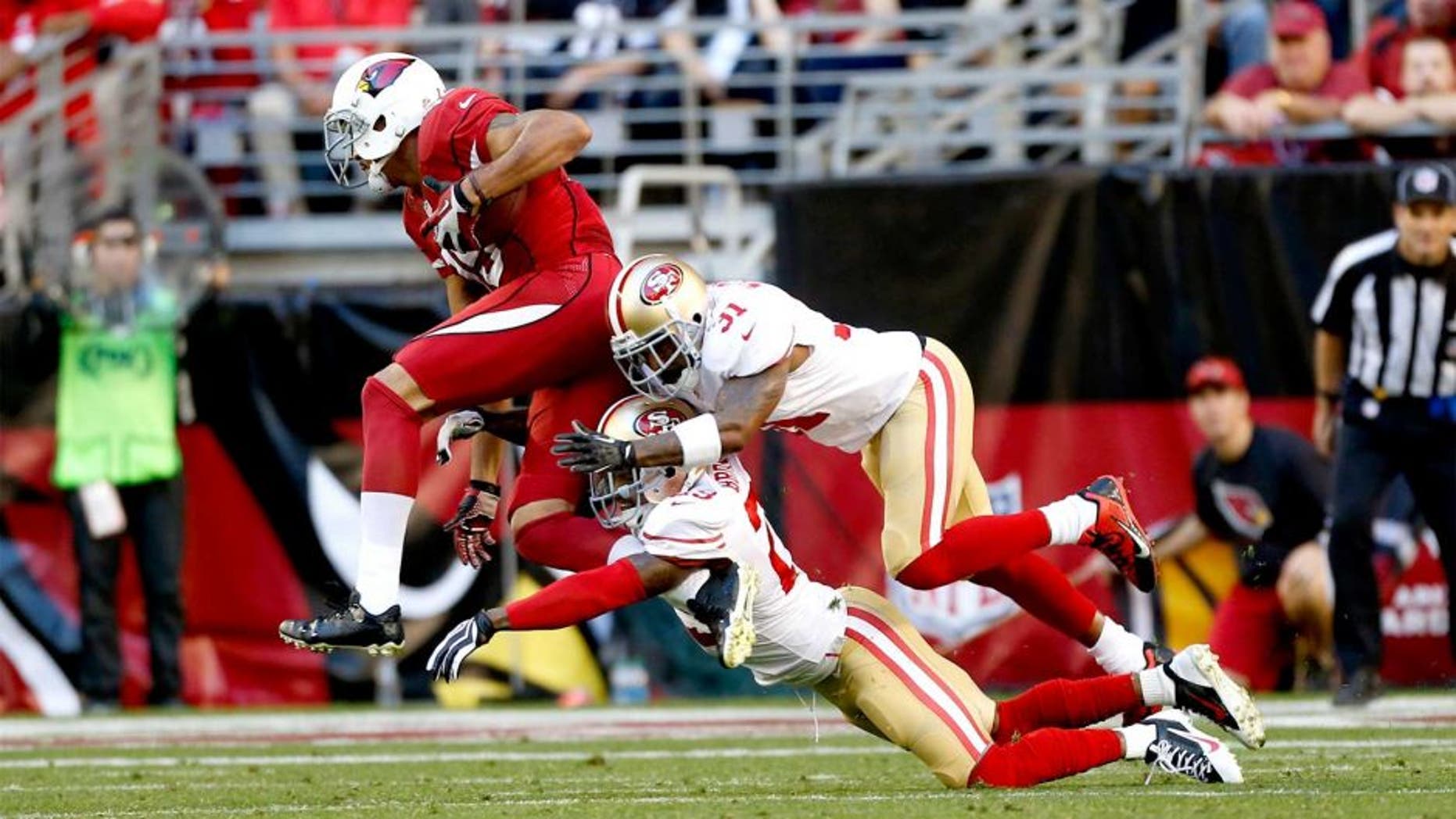 GLENDALE, AZ - DECEMBER 29: Tarell Brown #25 and Donte Whitner #31 of the San Francisco 49ers tackle Michael Floyd #15 of the Arizona Cardinals during the game at the University of Phoenix Stadium on December 29, 2013 in Glendale, Arizona. The 49ers defeated the Cardinals 23-20. (Photo by Michael Zagaris/San Francisco 49ers/Getty Images) *** Local Caption *** Tarell Brown;Donte Whitner;Michael Floyd