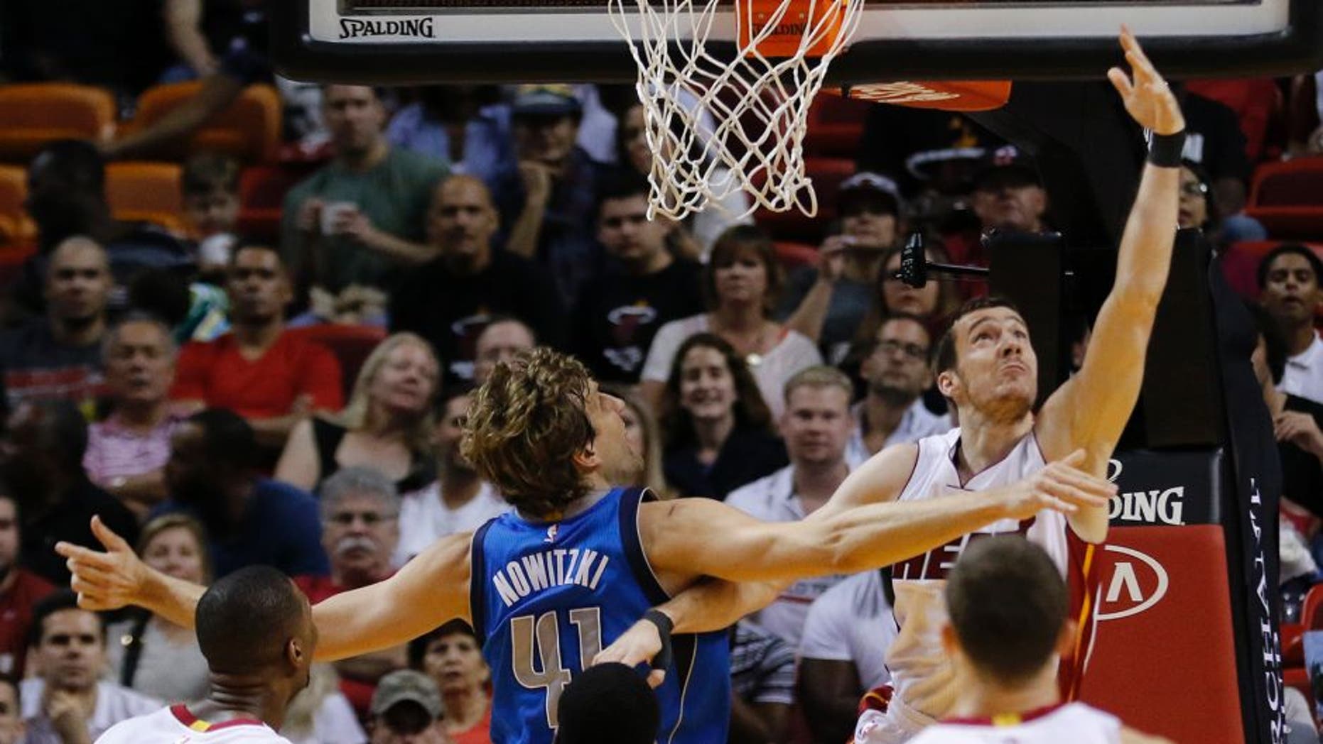 Miami Heat guard Goran Dragic (7) shoots as Dallas Mavericks forward Dirk Nowitzki (41) defends during the first half of an NBA basketball game, Friday, Jan. 1, 2016, in Miami. (AP Photo/Joe Skipper)