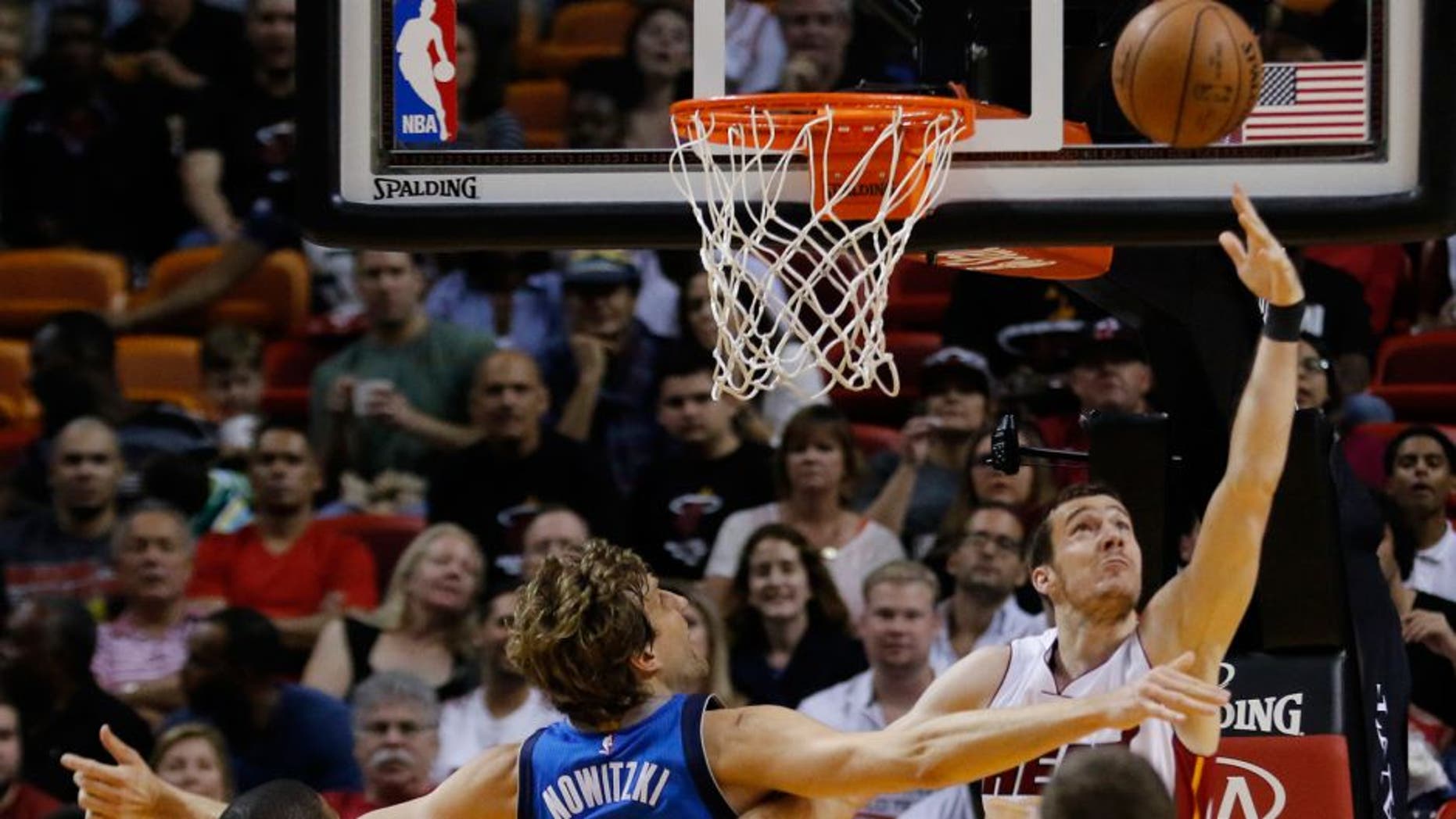 Miami Heat guard Goran Dragic (7) shoots as Dallas Mavericks forward Dirk Nowitzki (41) defends during the first half of an NBA basketball game, Friday, Jan. 1, 2016, in Miami. (AP Photo/Joe Skipper)