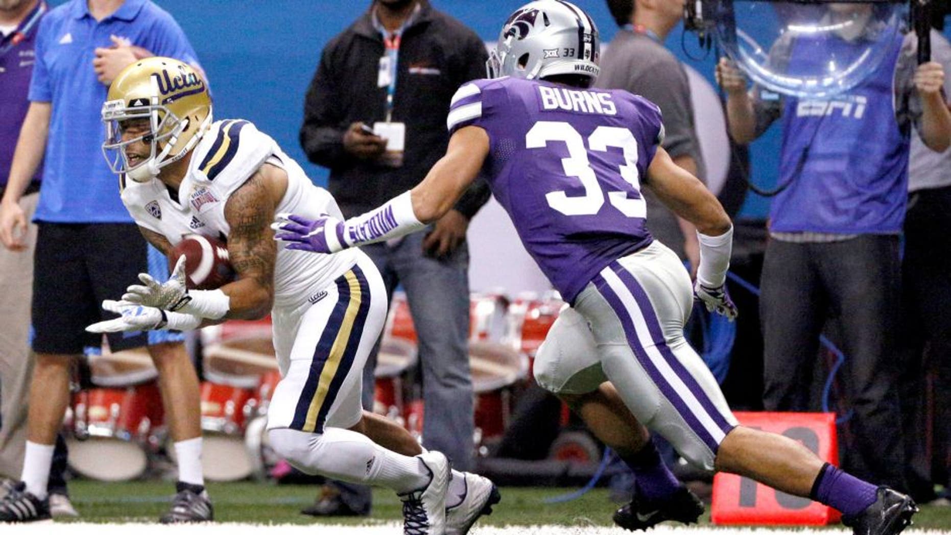 Jan 2, 2015; San Antonio, TX, USA; UCLA Bruins defensive back Priest Willis (15) catches the ball as Kansas State Wildcats defensive back Morgan Burns (33) defends during the first half of the 2015 Alamo Bowl at Alamodome. Mandatory Credit: Soobum Im-USA TODAY Sports