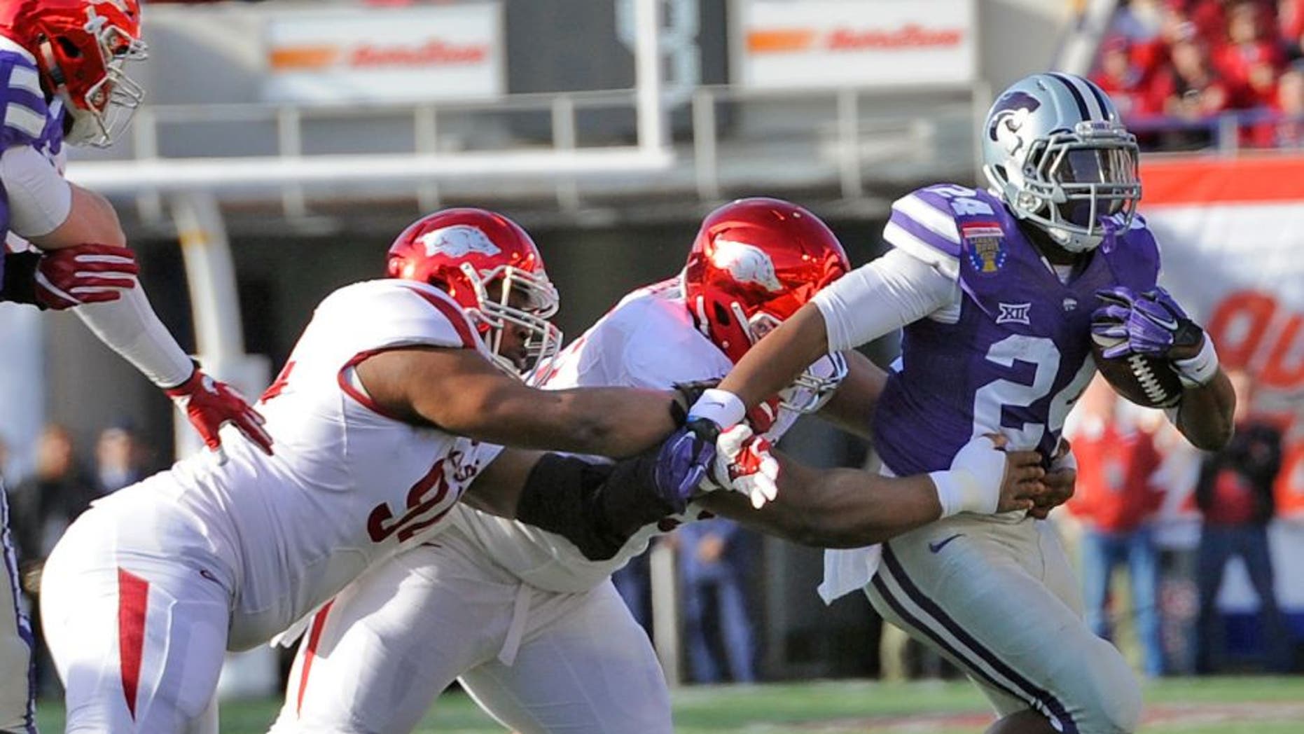 Jan 2, 2016; Memphis, TN, USA; Kansas State Wildcats running back Charles Jones (24) carries the ball against the Arkansas Razorbacks defense during the first half at Liberty Bowl. Mandatory Credit: Justin Ford-USA TODAY Sports