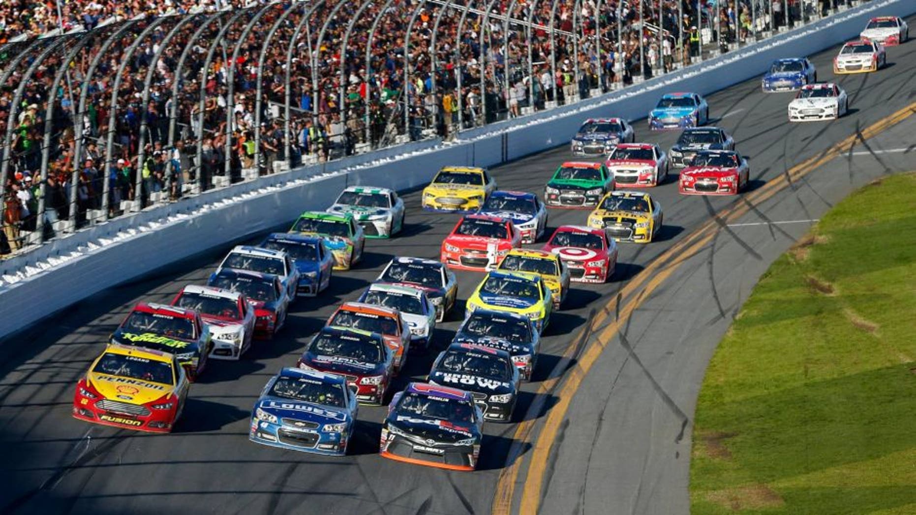 DAYTONA BEACH, FL - FEBRUARY 22: Joey Logano, driver of the #22 Shell Pennzoil Ford, Jimmie Johnson, driver of the #48 Lowe's Chevrolet, and Denny Hamlin, driver of the #11 FedEx Express Toyota, race three-wide at the front of the field during the NASCAR Sprint Cup Series 57th Annual Daytona 500 at Daytona International Speedway on February 22, 2015 in Daytona Beach, Florida. (Photo by Jonathan Ferrey/NASCAR via Getty Images)