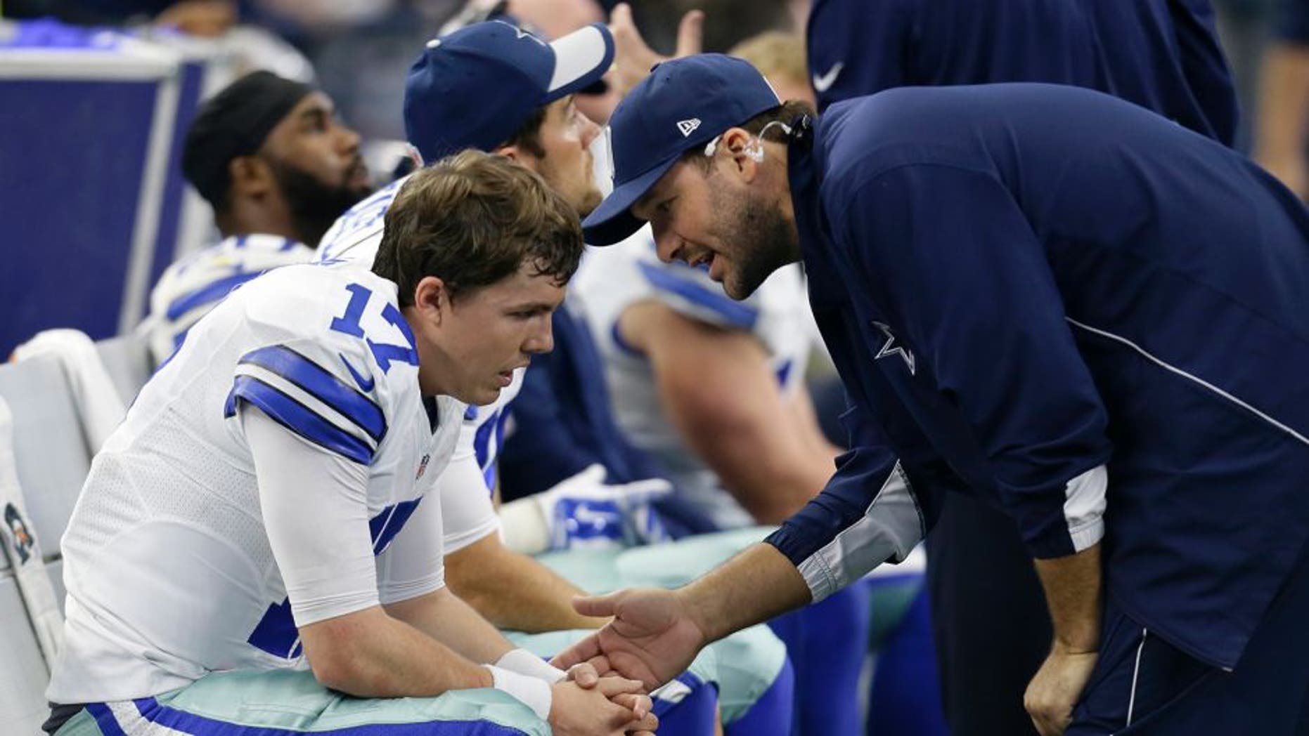 Dallas Cowboys quarterback Kellen Moore, left, talks with injured quarterback Tony Romo, right, in the second half of an NFL football game against the Washington Redskins on Sunday, Jan. 3, 2016, in Arlington, Texas. (AP Photo/Tim Sharp)