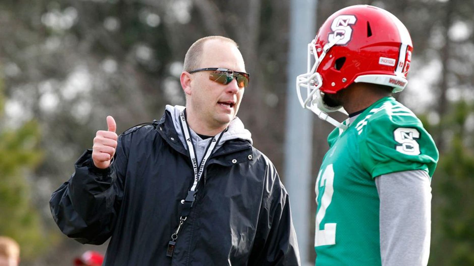 N.C. State Wolfpack offensive coordinator Matt Canada talks with Jacoby Brissett (12) during spring football practice in Raleigh, N.C., on Wednesday, March 5, 2014. (Ethan Hyman/Raleigh News & Observer/MCT)
