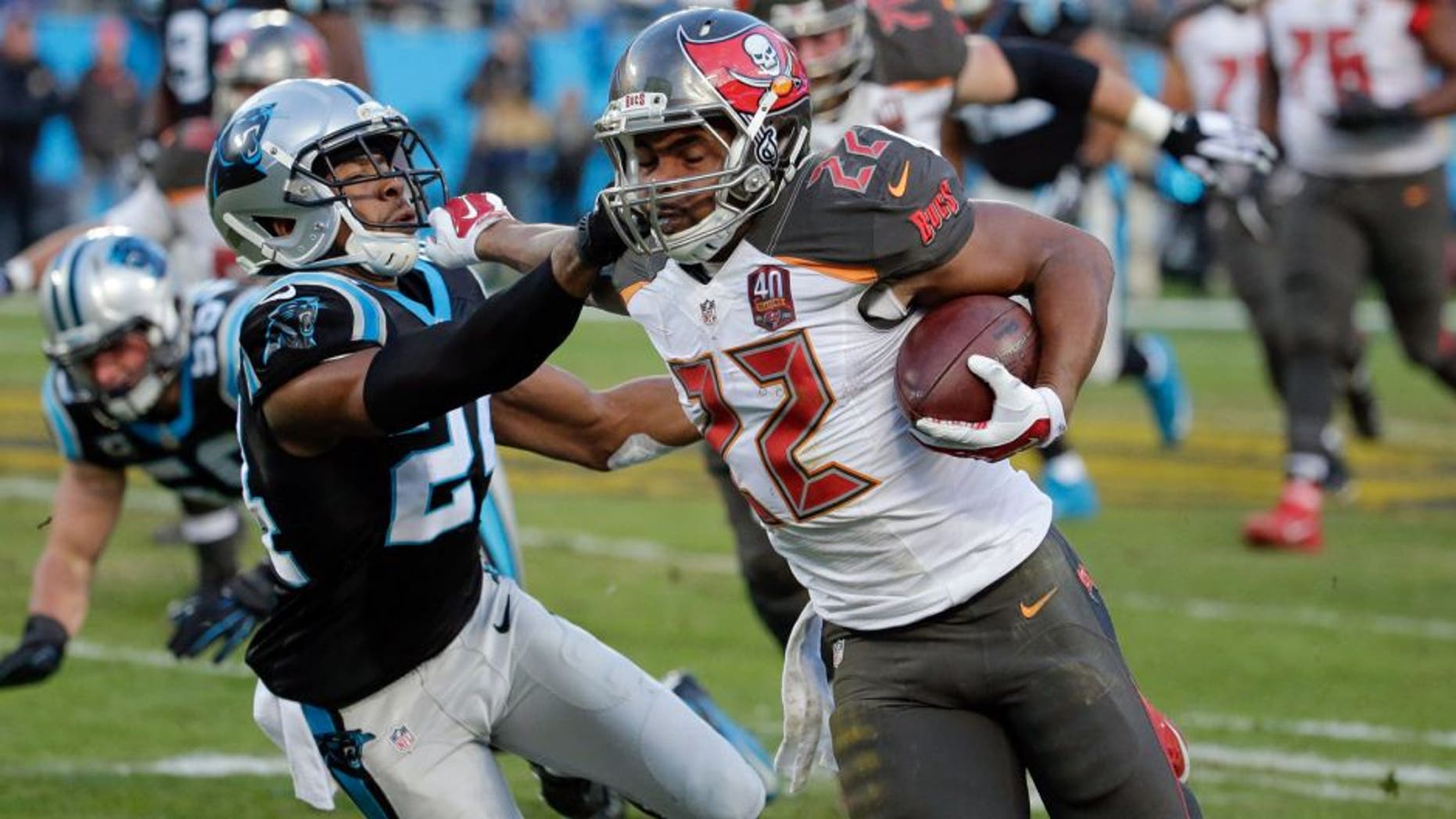 Jan 3, 2016; Charlotte, NC, USA; Tampa Bay Buccaneers running back Doug Martin (22) stiff arms Carolina Panthers cornerback Josh Norman (24) during the second quarter at Bank of America Stadium. Mandatory Credit: Jeremy Brevard-USA TODAY Sports