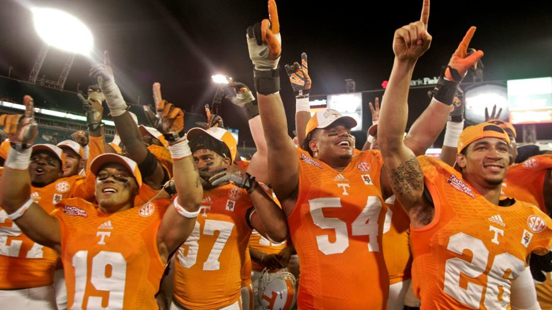 Jan 2, 2015; Jacksonville, FL, USA; Tennessee Volunteers running back Devrin Young (19) and defensive back Brian Randolph (37) and defensive tackle Jordan Williams (54) and defensive back Geraldo Orta (26) celebrate with fans after their 2015 TaxSlayer Bowl game against the Iowa Hawkeyes at EverBank Field. The Tennessee Volunteers beat the Iowa Hawkeyes 45-28. Mandatory Credit: Phil Sears-USA TODAY Sports