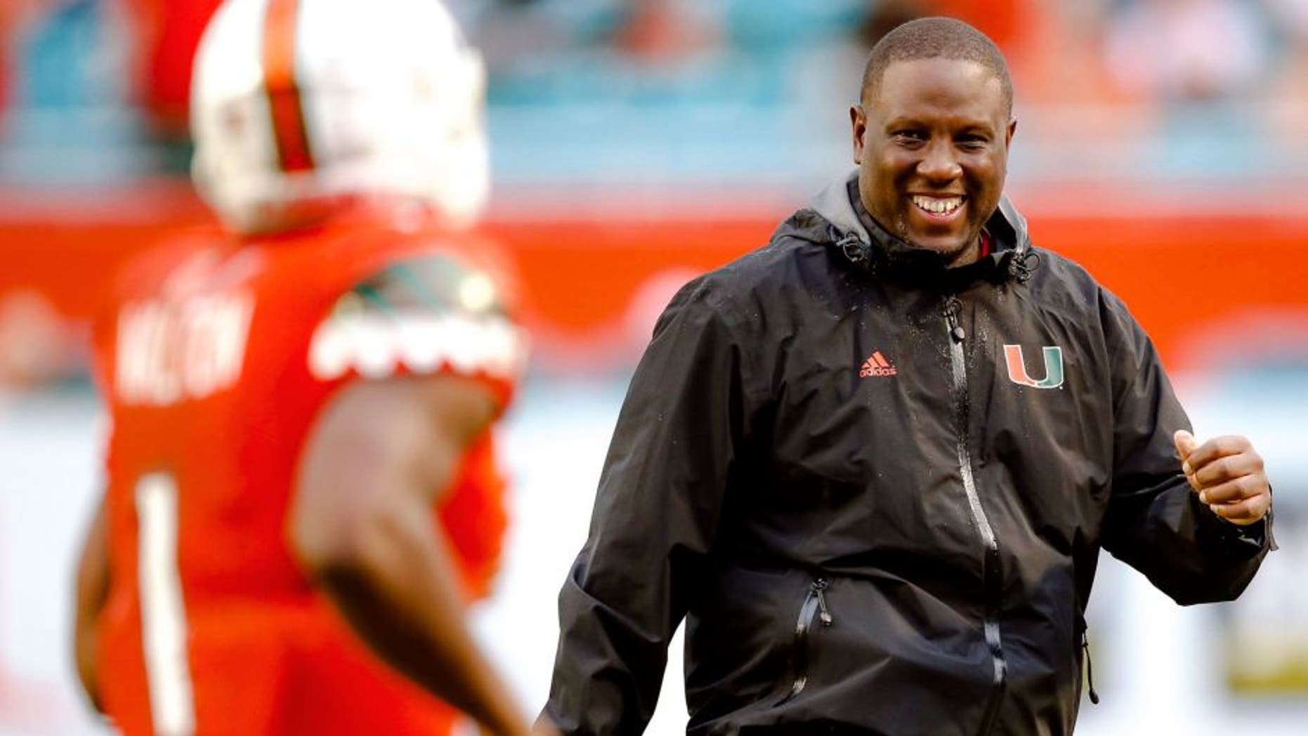 Nov 21, 2015; Miami Gardens, FL, USA; Miami Hurricanes interim head coach Larry Scott (right) greets Hurricanes running back Mark Walton (left) after Walton scored a touchdown against the Georgia Tech Yellow Jackets during the second half at Sun Life Stadium. Mandatory Credit: Steve Mitchell-USA TODAY Sports