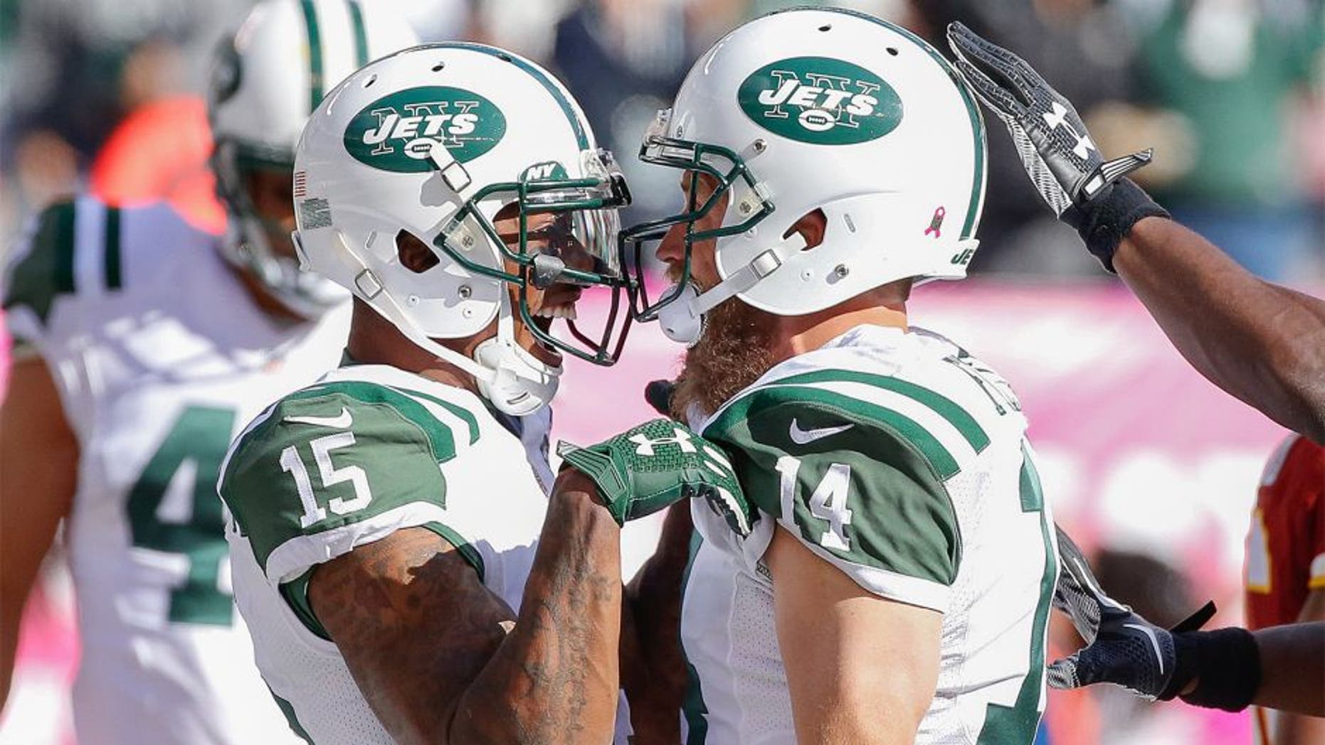 Oct 18, 2015; East Rutherford, NJ, USA; New York Jets quarterback Ryan Fitzpatrick (14) celebrates with wide receiver Brandon Marshall (15) after scoring a touchdown in the second half against the Washington Redskins at MetLife Stadium. The Jets won 34-20. Mandatory Credit: Vincent Carchietta-USA TODAY Sports