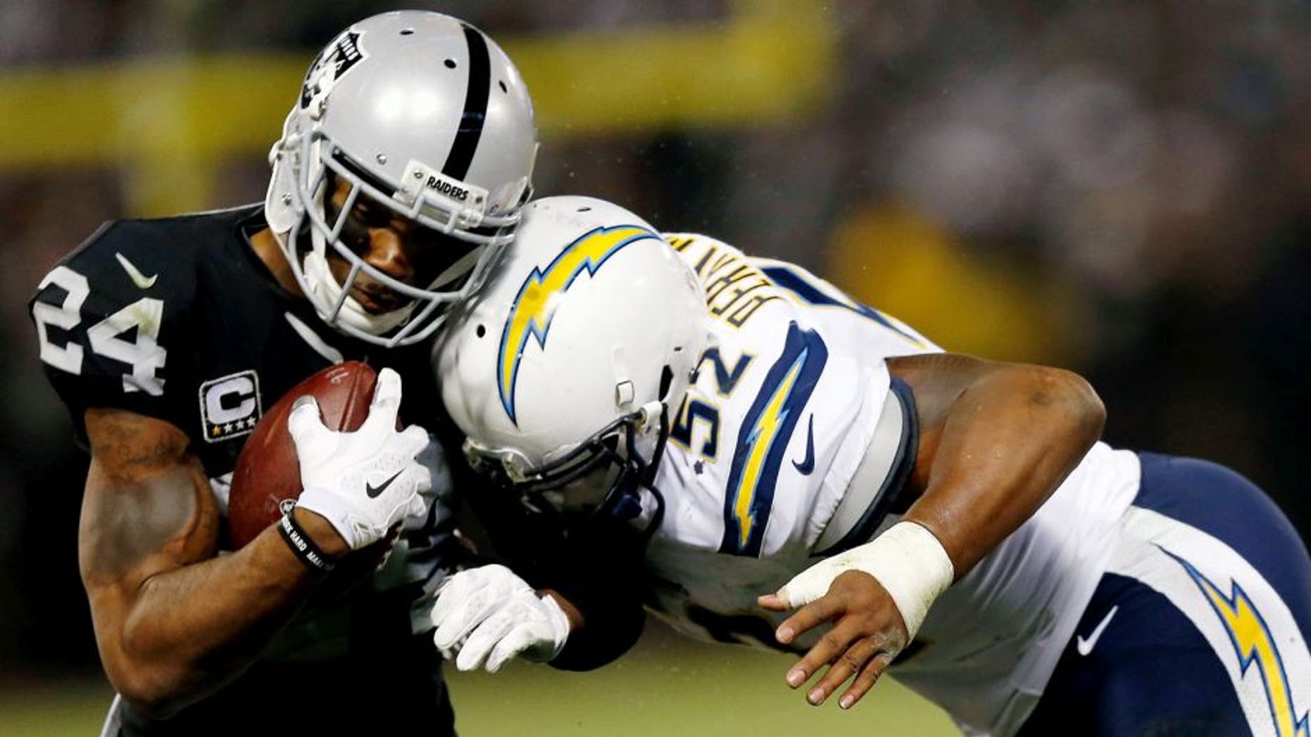 OAKLAND, CA - DECEMBER 24: Safety Charles Woodson #24 of the Oakland Raiders is tackled by linebacker Denzel Perryman #52 of the San Diego Chargers in overtime at O.co Coliseum on December 24, 2015 in Oakland, California. (Photo by Lachlan Cunningham/Getty Images)