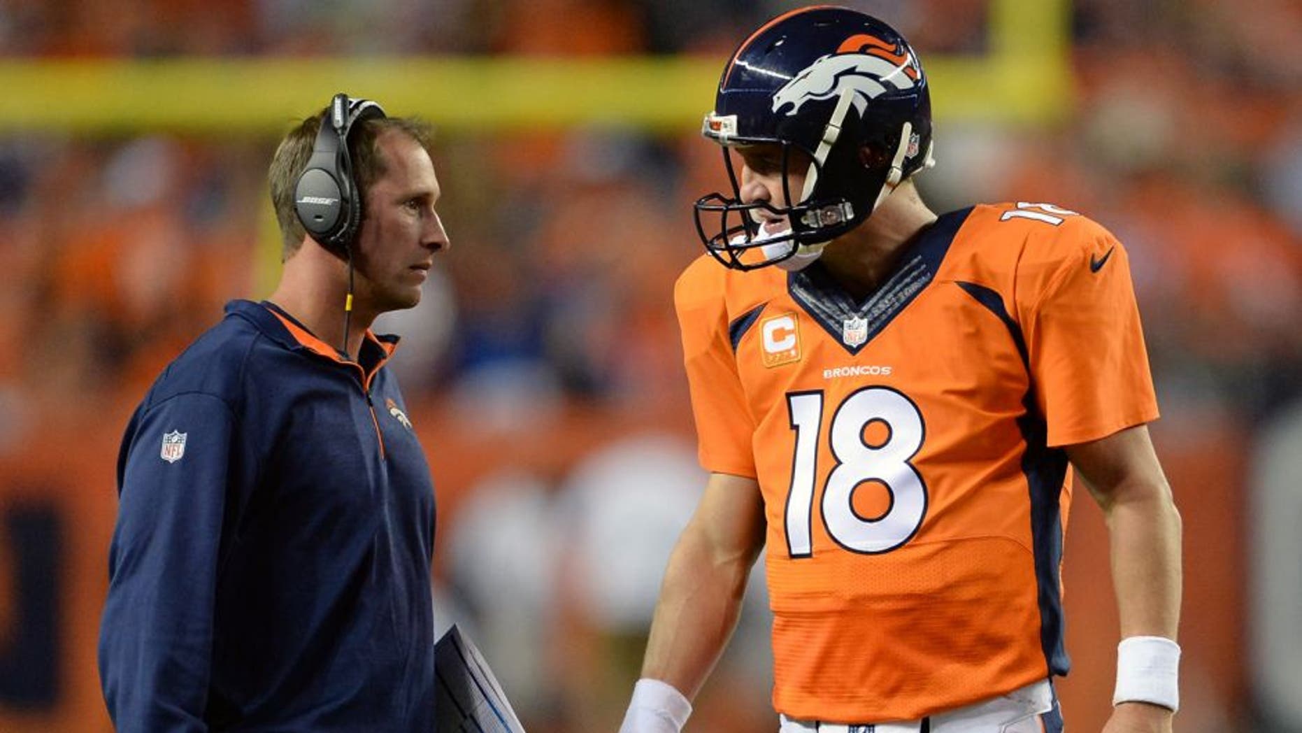 Sep 7, 2014; Denver, CO, USA; Denver Broncos offensive coordinator Adam Gase and quarterback Peyton Manning (18) speak in the second quarter against the Indianapolis Colts at Sports Authority Field at Mile High. The Broncos defeated the Colts 31-24. Mandatory Credit: Ron Chenoy-USA TODAY Sports