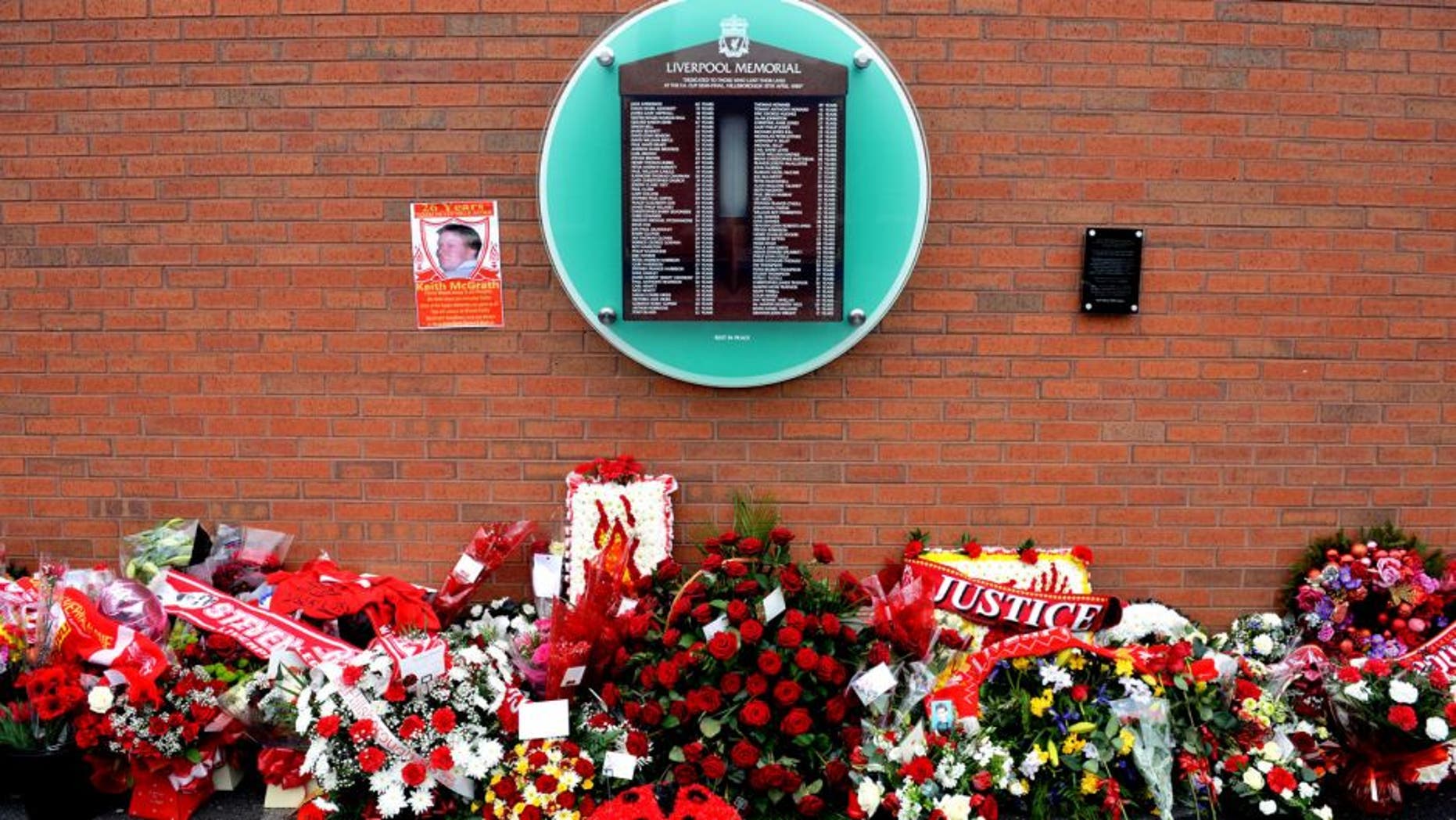 Flowers sit beneath the temporary Hillsborough memorial, ahead of a memorial service at Anfield in Liverpool, north west Engand on April 15, 2015, on the 26th anniversary of the Hillsborough Disaster, where 96 Liverpool supporters died at the 1989 FA Cup semi final between Liverpool and Nottingham Forest at Hillsborough football ground in Sheffield. AFP PHOTO / PAUL ELLIS (Photo credit should read PAUL ELLIS/AFP/Getty Images)