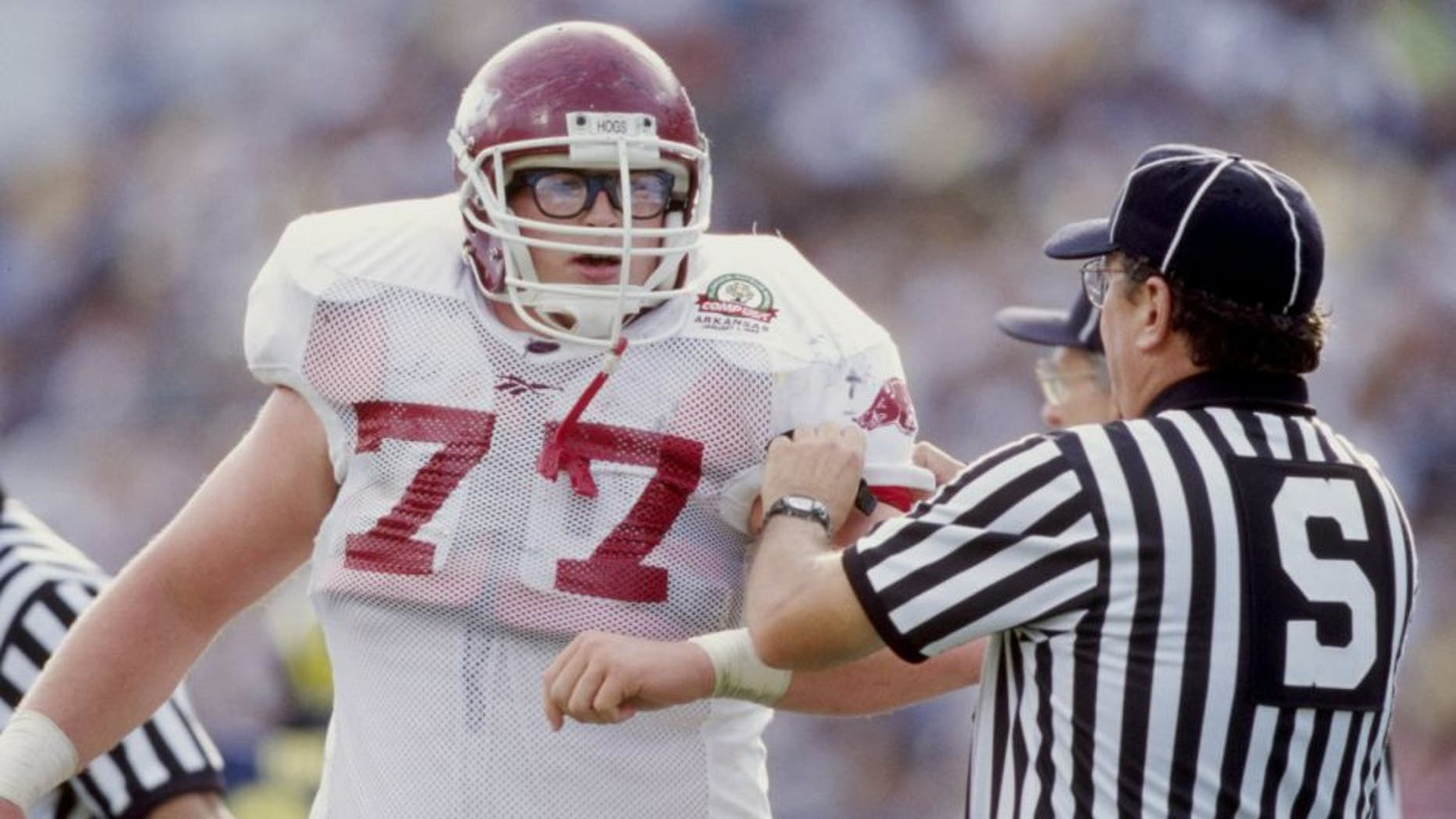 1 Jan 1999: Brandon Burlsworth #77 of the Arkansas Razorbacks is helped by an official during the Citrus Bowl against the Michigan Wolverines at the Florida Citrus Bowl in Orlando, Florida. Michigan defeated Arkansas 45-31. Mandatory Credit: Andy Lyons /Allsport