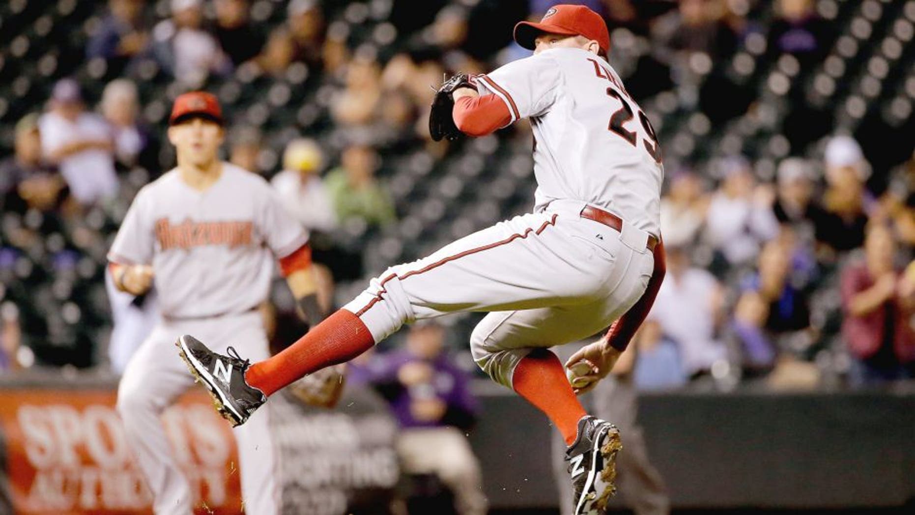 DENVER, CO - AUGUST 31: Relief pitcher Brad Ziegler #29 of the Arizona Diamondbacks makes a throwing error after fielding a ground ball by DJ LeMahieu #9 of the Colorado Rockies in the ninth inning at Coors Field on August 31, 2015 in Denver, Colorado. Ziegler would collect the loss as the Rockies defeated the Diamondbacks 5-4. (Photo by Doug Pensinger/Getty Images)