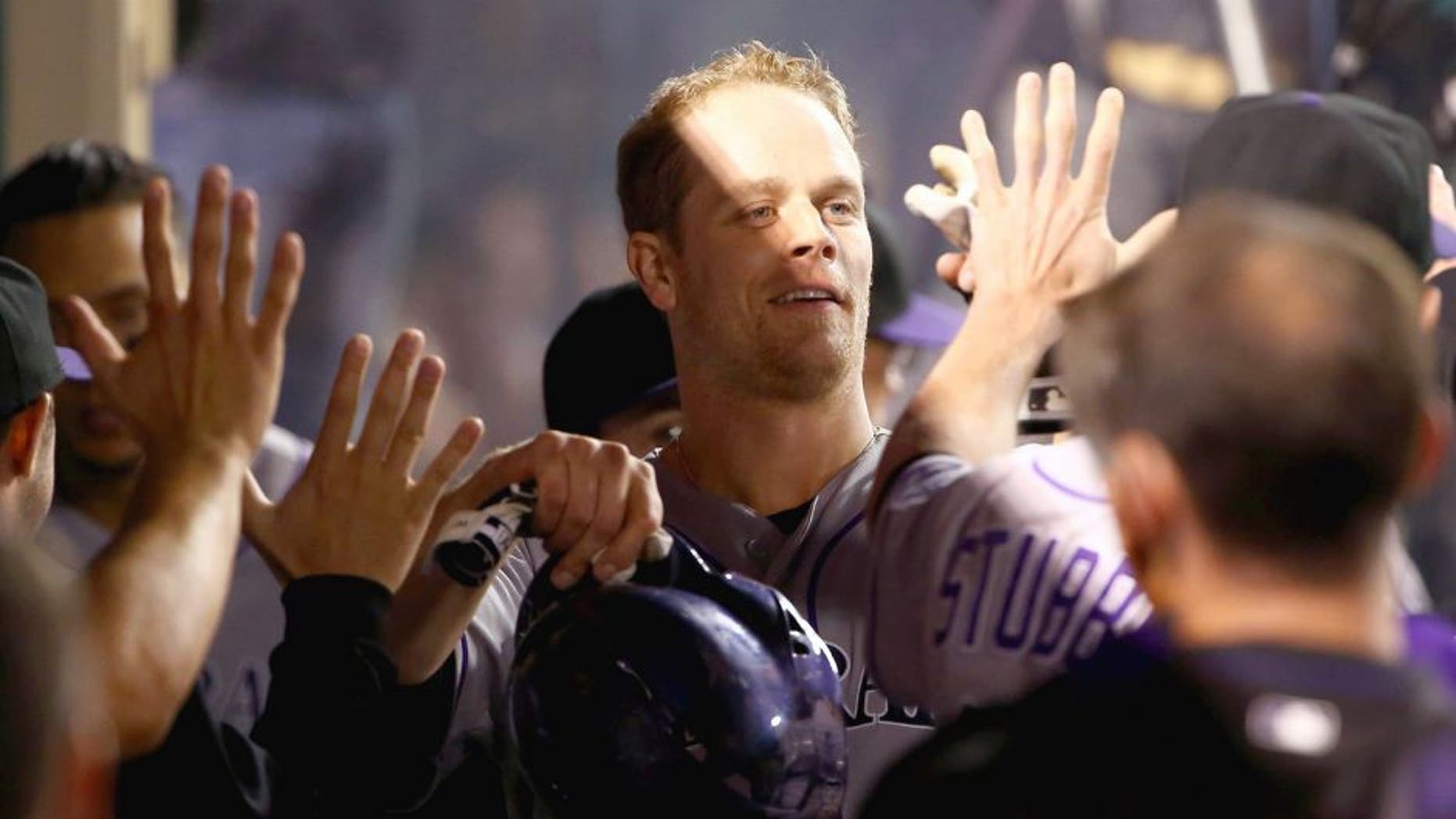 ANAHEIM, CA - MAY 12: Justin Morneau #33 of the Colorado Rockies celebrates in the dugout after scoring on Corey Dickerson's rbi double to deep right field in the fourth inning during the MLB game against the Los Angeles Angels of Anaheim at Angel Stadium of Anaheim on May 12, 2015 in Anaheim, California. The Angels defeated the Rockies 5-2. (Photo by Victor Decolongon/Getty Images)