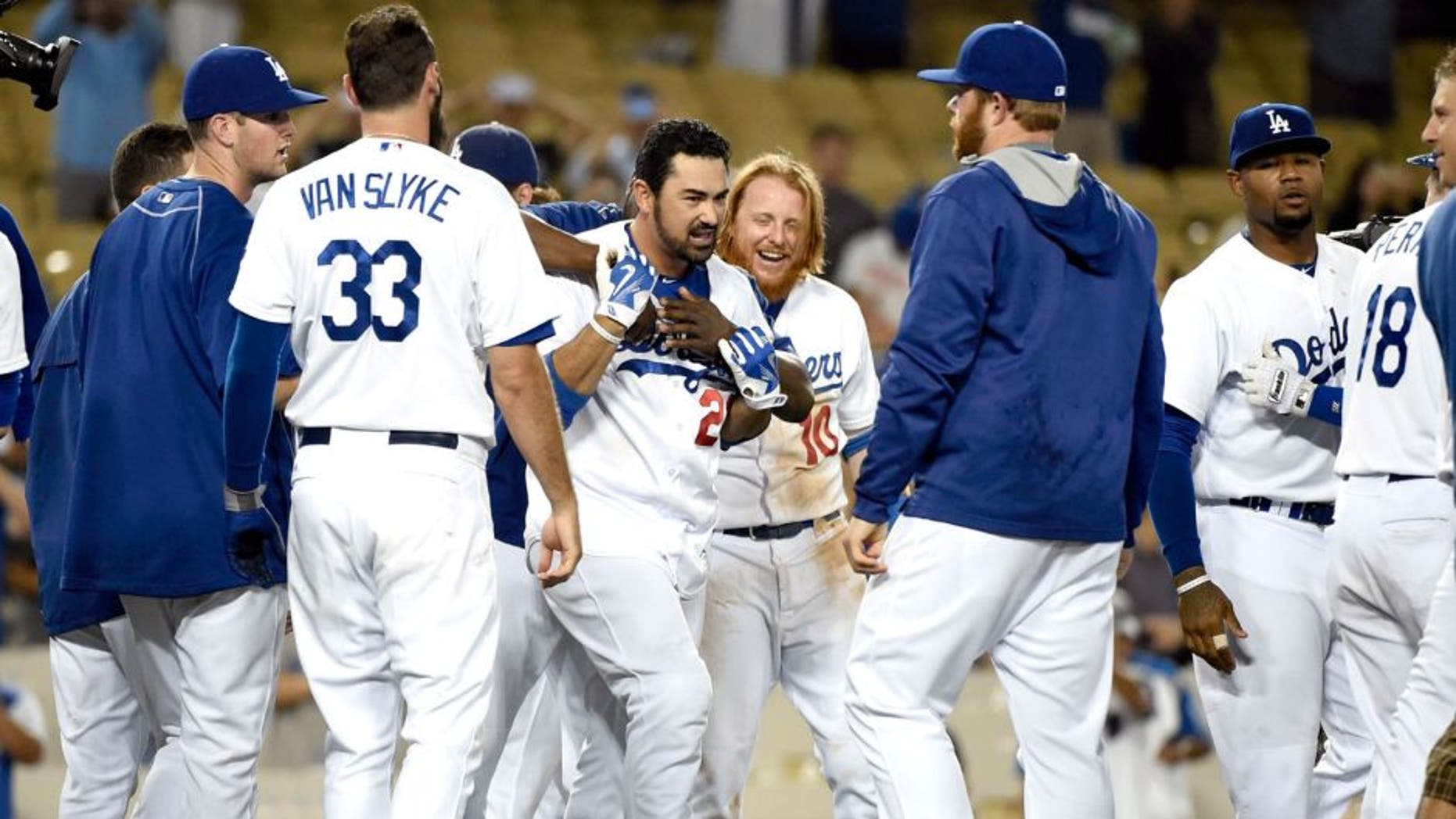 Aug 31, 2015; Los Angeles, CA, USA; Los Angeles Dodgers first baseman Adrian Gonzalez (23) celebrates with teammates after hitting a walk off during the fourteenth inning against the San Francisco Giants at Dodger Stadium. Mandatory Credit: Richard Mackson-USA TODAY Sports