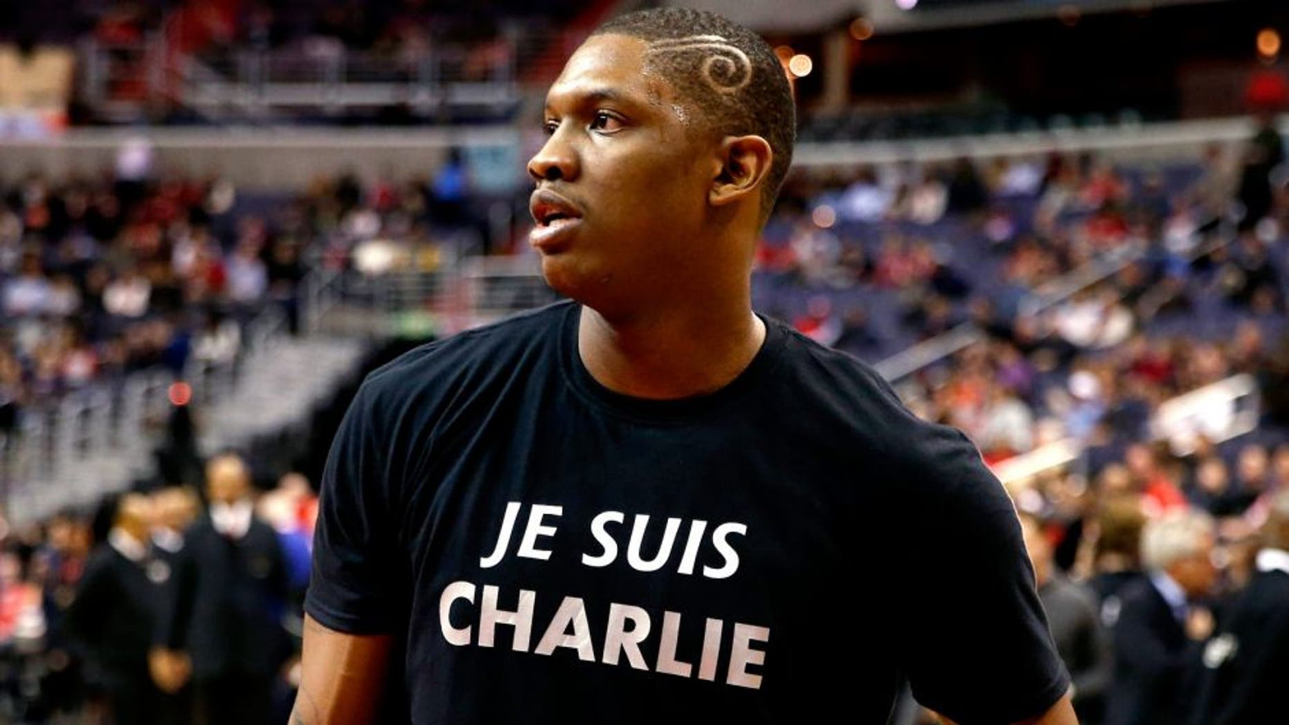 Washington Wizards center Kevin Seraphin, from France, wears a "Je Suis Charlie" T-shirt during warmups for an NBA basketball game against the Chicago Bulls, Friday, Jan. 9, 2015, in Washington. "Je Suis Charlie" ó "I Am Charlie" in English ó has become a worldwide slogan to show solidarity with Charlie Hebdo, a Paris weekly newspaper where 12 people were killed Wednesday in a terrorist attack. Seraphin was born in French Guiana and has represented France in international competitions. (AP Photo/Alex Brandon)