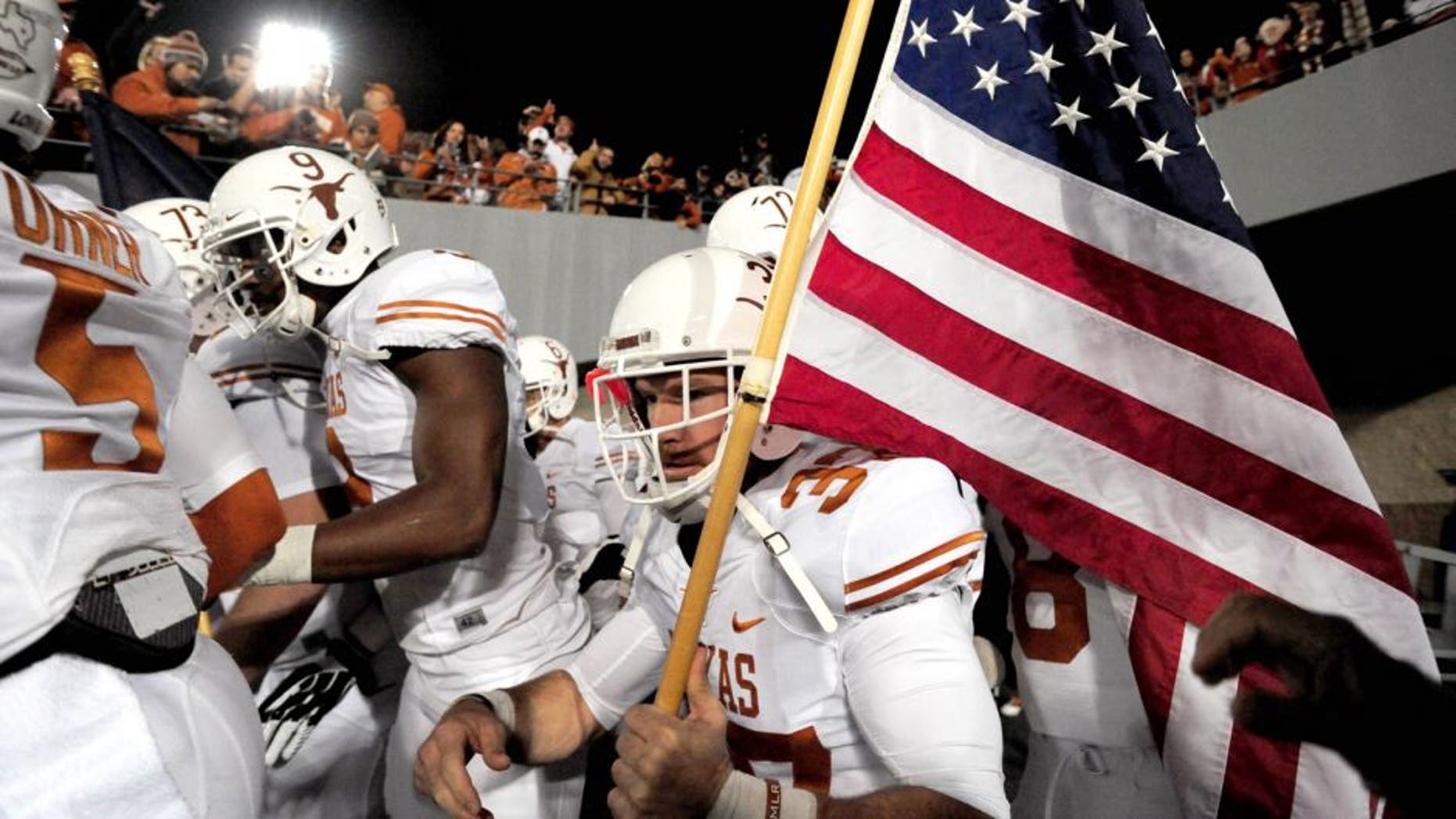 Nov 9, 2013; Morgantown, WV, USA; Texas Longhorns deep snapper Nate Boyer (37) carries a flag onto the field prior to the game against the West Virginia Mountaineers at Milan Puskar Stadium. Mandatory Credit: Evan Habeeb-USA TODAY Sports