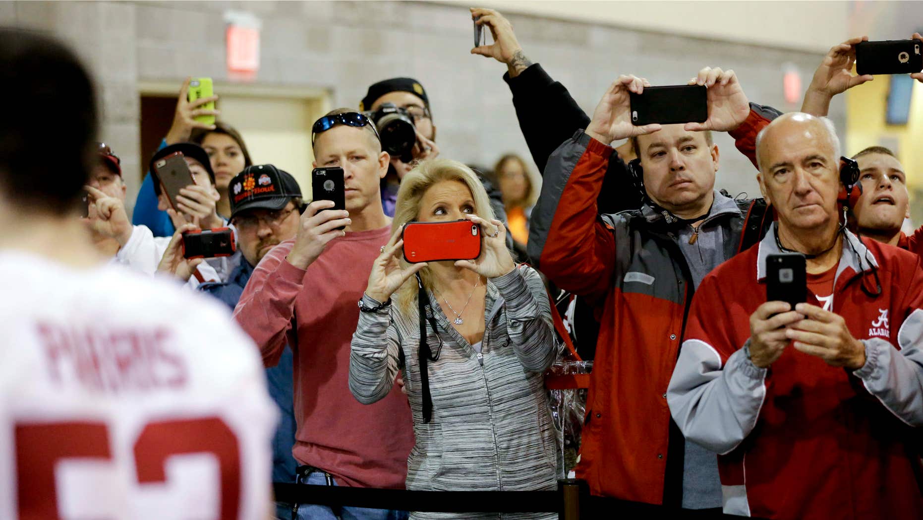 Jan. 9, 2016: Fans take pictures as the team from Alabama leaves after media day for the NCAA College Football Playoff National Championship in Phoenix.