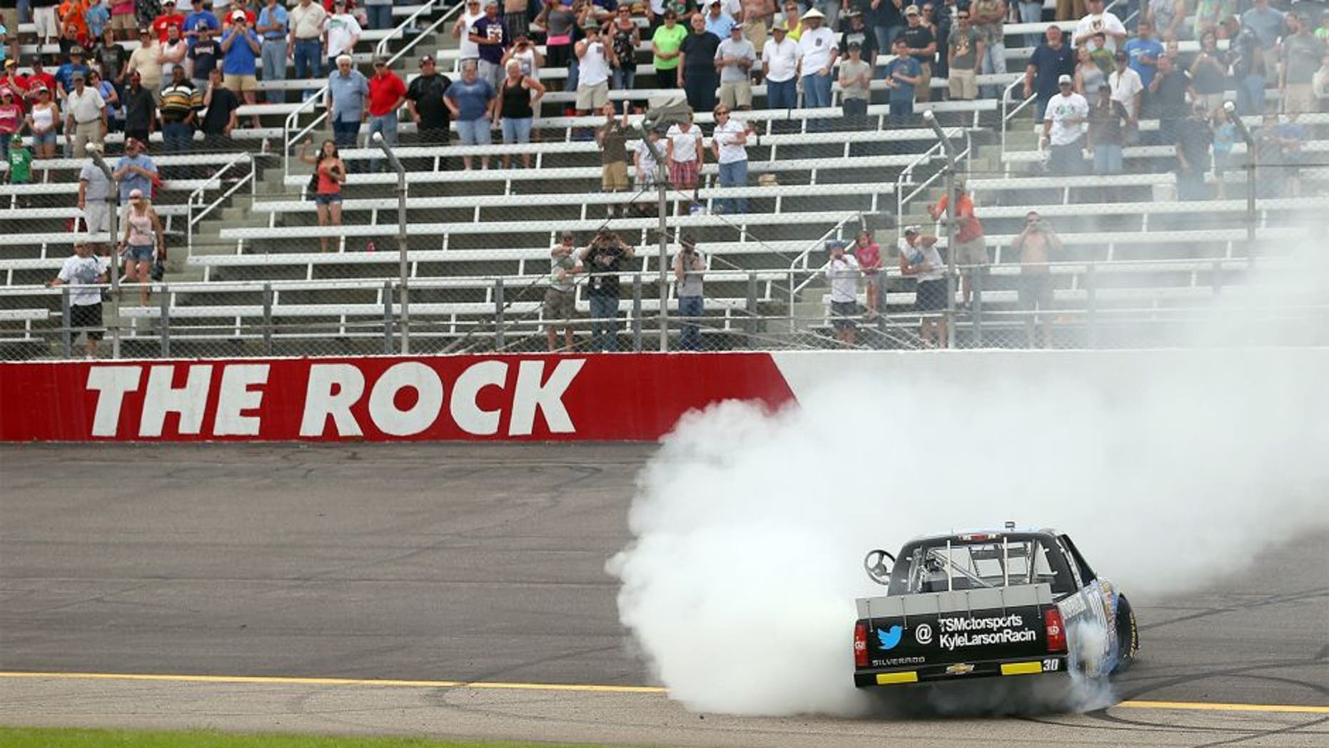 ROCKINGHAM, NC - APRIL 14: Kyle Larson, driver of the #30 Autism Speaks Chevrolet, does a burn out after winning the NASCAR Camping World Truck Series Carolina 200 at Rockingham Speedway on April 14, 2013 in Rockingham, North Carolina. (Photo by Streeter Lecka/Getty Images)