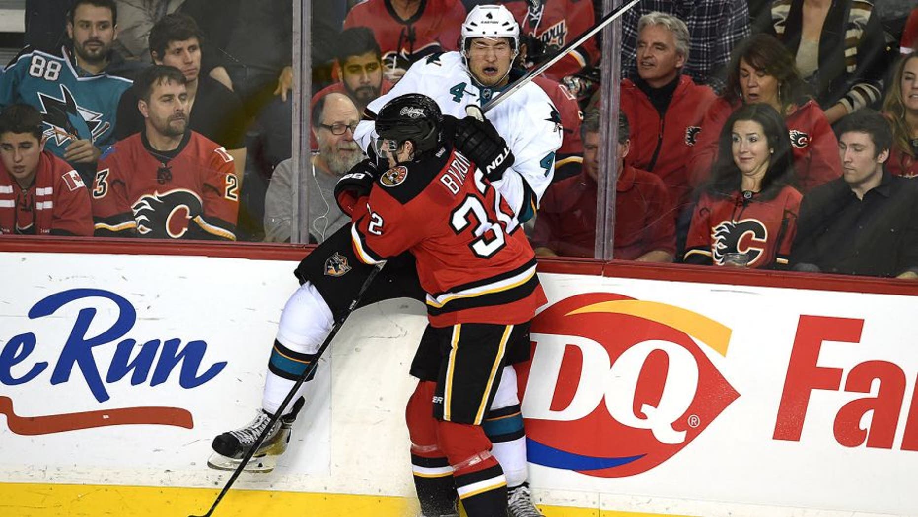 Dec 6, 2014; Calgary, Alberta, CAN; Calgary Flames center Paul Byron (32) checks San Jose Sharks defenseman Brenden Dillon (4) at Scotiabank Saddledome. Sharks won 3-2. Mandatory Credit: Candice Ward-USA TODAY Sports