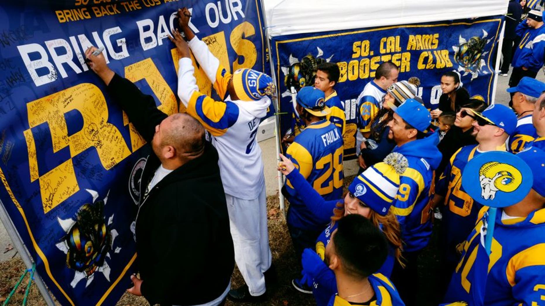 Rams fans sign a banner in support of their team at the historic Los Angeles Memorial Coliseum. Saturday, Jan. 9, 2016 in Los Angeles. Boisterous Los Angeles Rams fans gathered Saturday to herald the NFL football team's possibly imminent return to Southern California after a 21-year sojourn in St. Louis. (AP Photo/Richard Vogel)