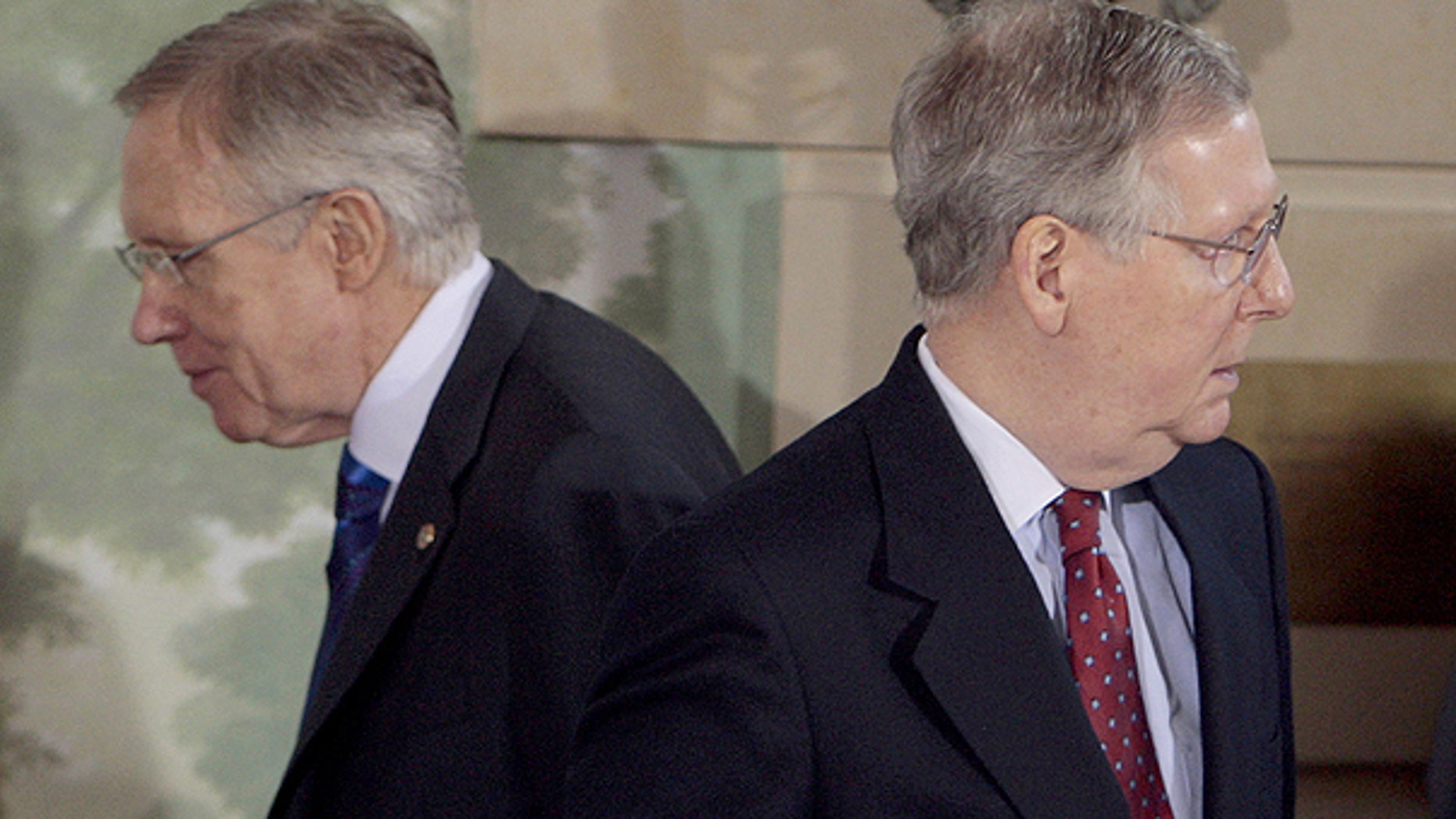 In this Feb. 25, 2010, file photo Senate Majority Leader Harry Reid of Nev., left, walks past Senate Minority Leader Mitch McConnell of Ky., during a meeting at the Blair House in Washington.