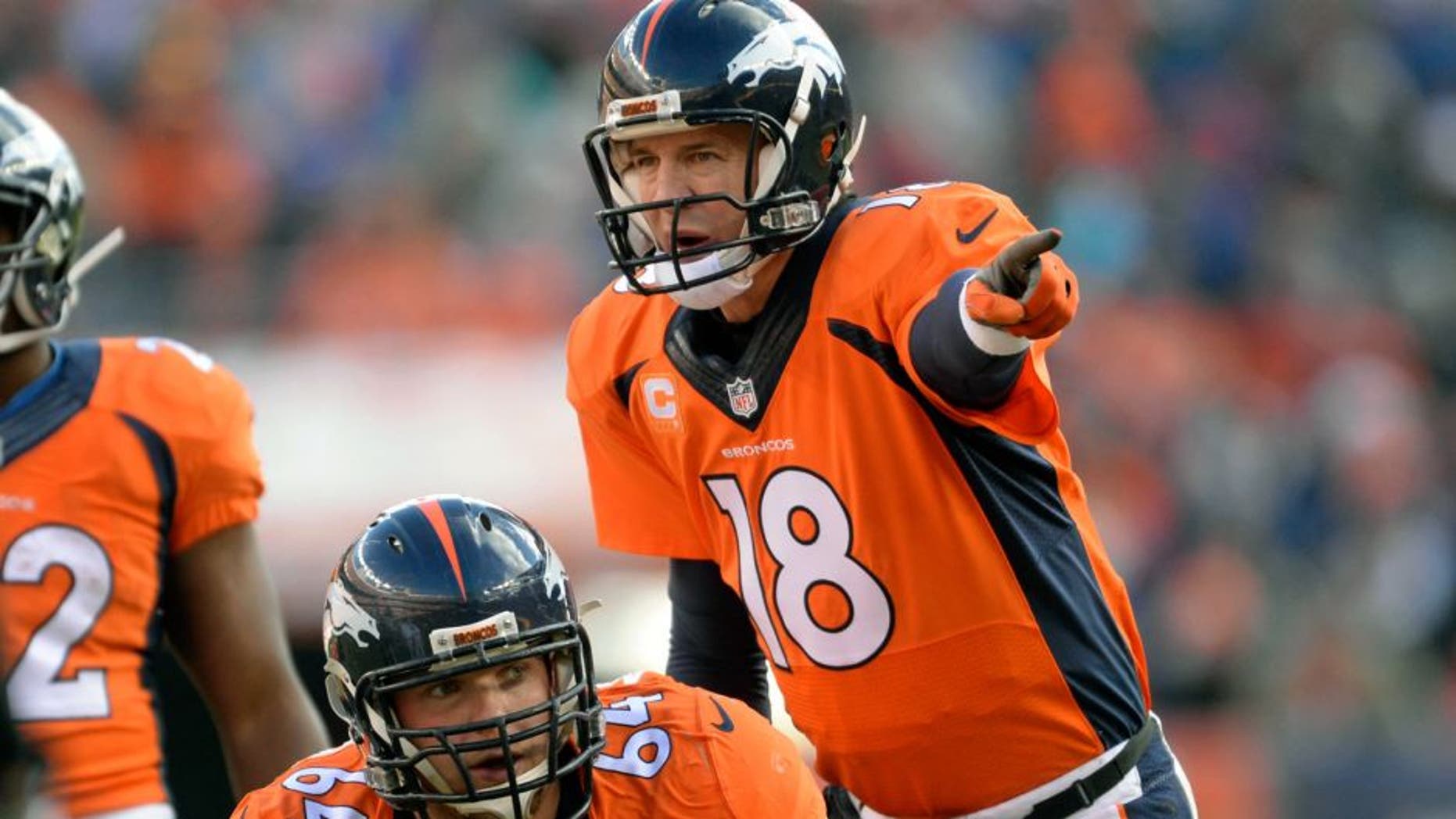 Dec 28, 2014; Denver, CO, USA; Denver Broncos quarterback Peyton Manning (18) calls an audible over center Will Montgomery (64) in the first quarter against the Oakland Raiders at Sports Authority Field at Mile High. Mandatory Credit: Ron Chenoy-USA TODAY Sports