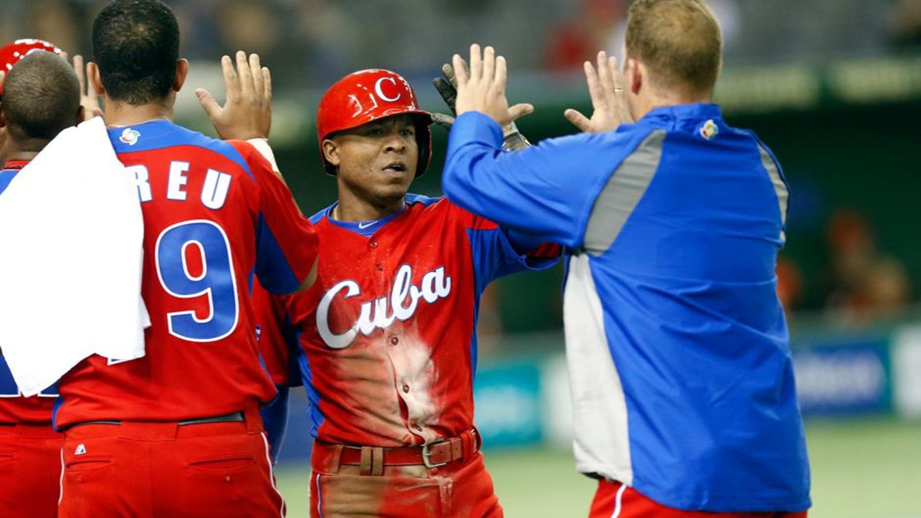 TOKYO, JAPAN - MARCH 11: Alexei Bell #88 of Team Cuba is greeted by teammates after scoring a run in the top of the fifth inning during action against Team Netherlands Pool 1, Game 5 in the second round of the 2013 World Baseball Classic at the Tokyo Dome on March 11, 2013 in Tokyo, Japan. (Photo by Yuki Taguchi/WBCI/MLB Photos via Getty Images)