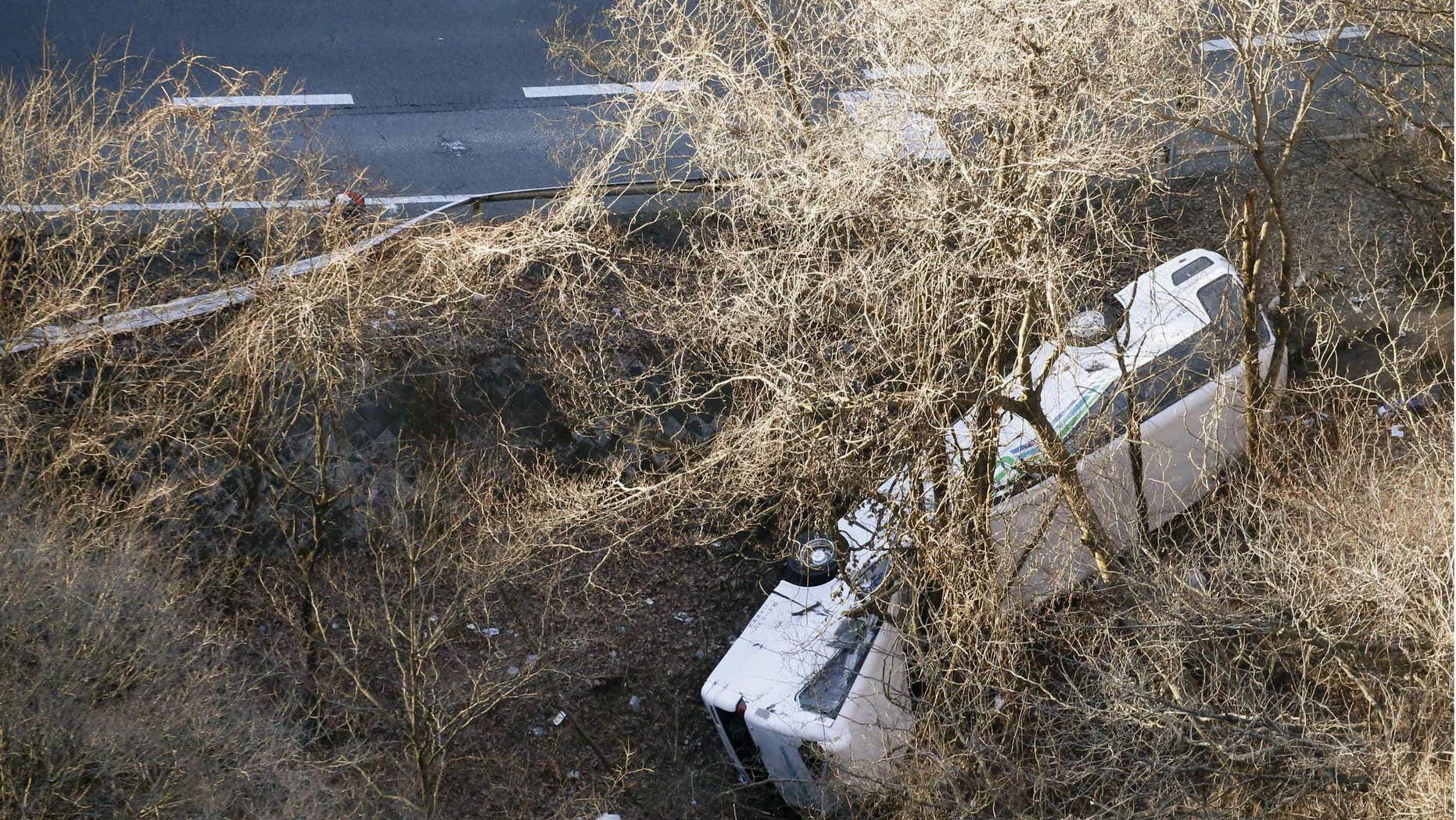 Jan. 15, 2016: A bus lies after it veered off to the opposite lane on a mountain road in Karuizawa, Nagano prefecture, central Japan.