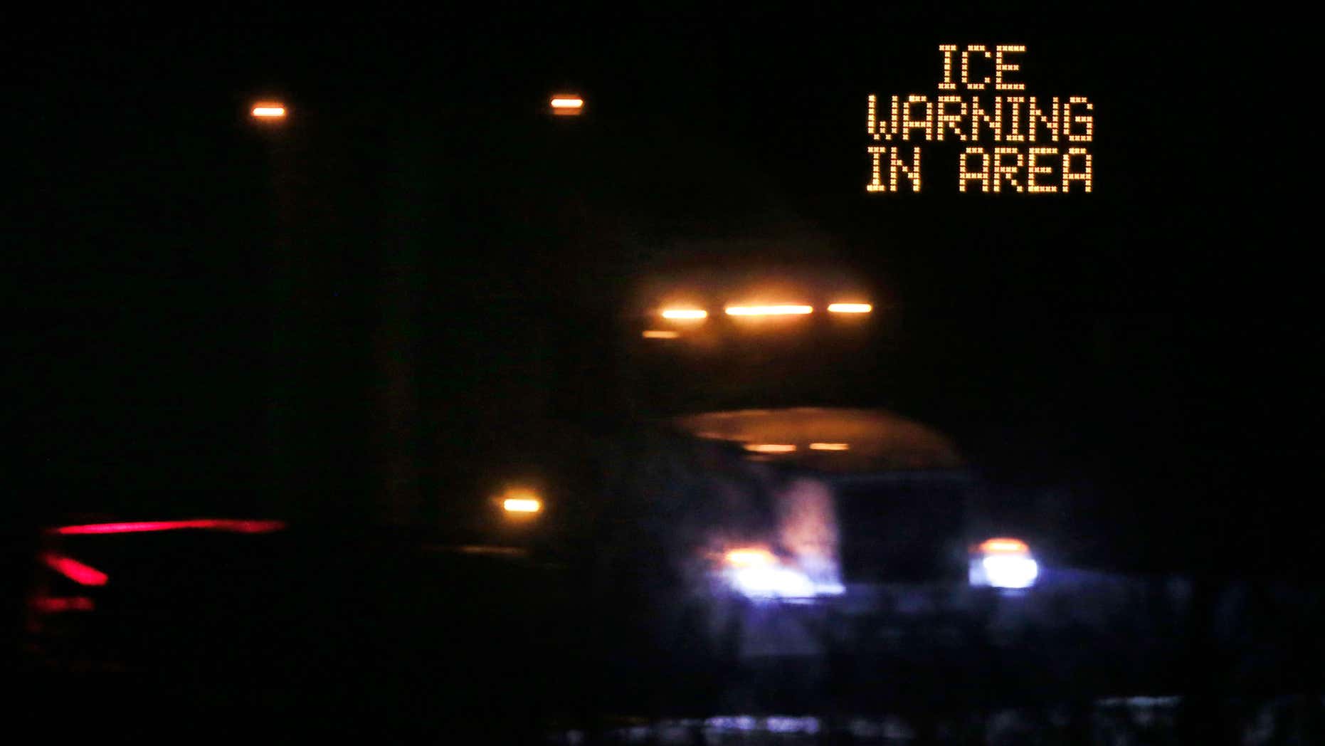 Jan. 14, 2017: Traffic moves past an icing warning sign at night on I-70 west Lawrence, Kan.