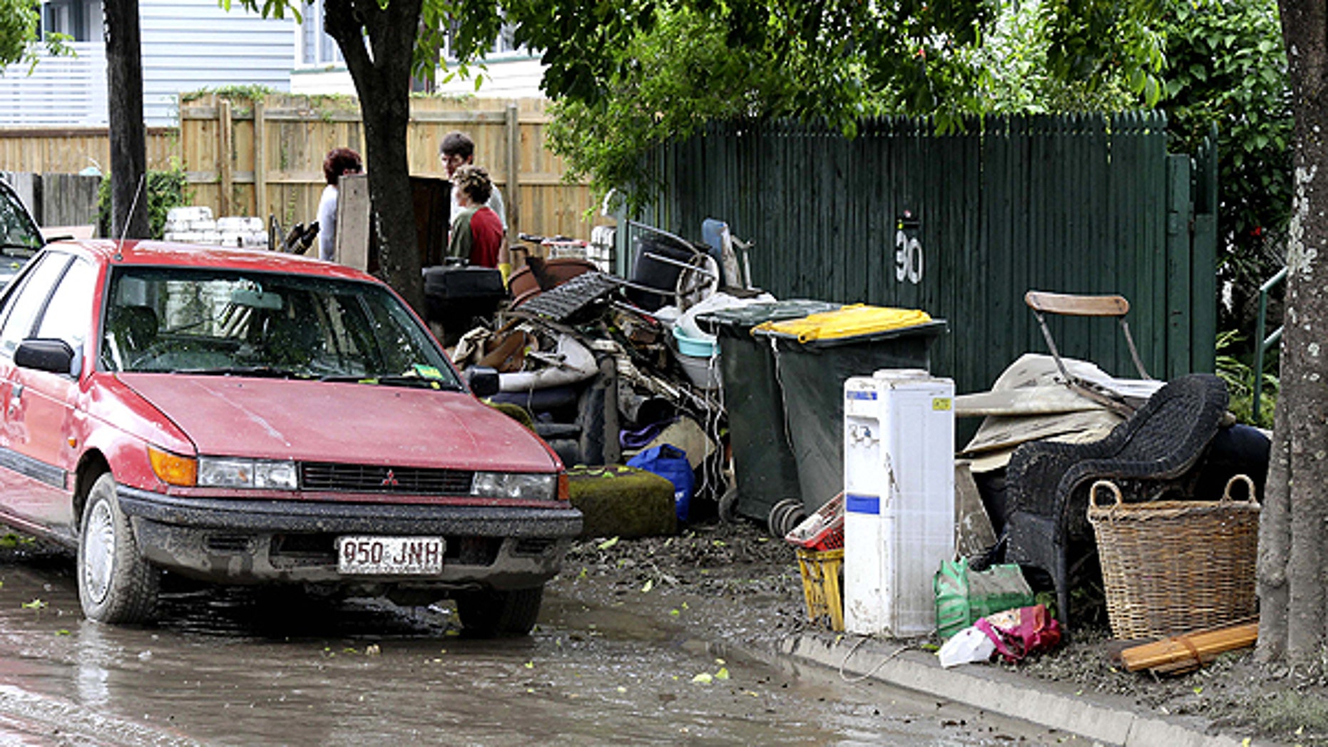 Jan. 14: Damaged goods await removal in front of a flooded home in Brisbane, Australia.