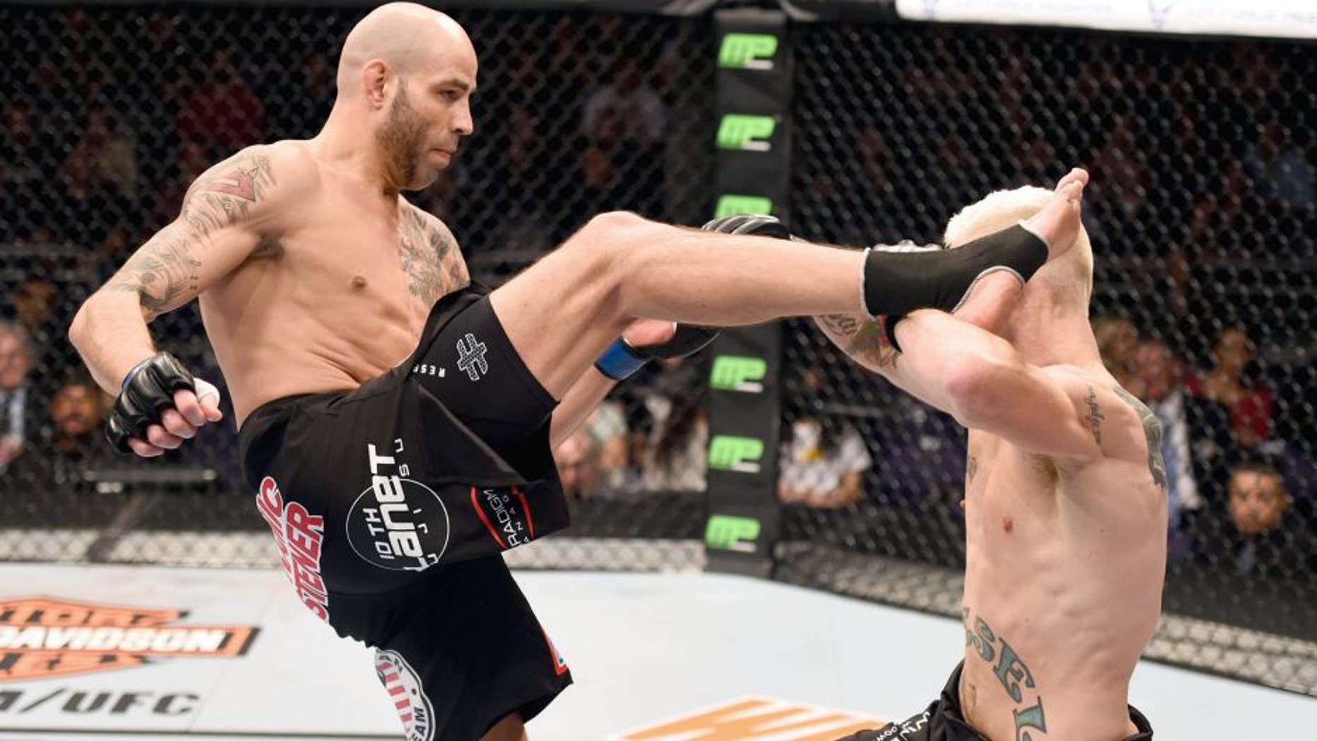 PHOENIX, AZ - DECEMBER 13: (L-R) Ben Saunders kicks Joe Riggs in their welterweight fight during the UFC Fight Night event at the U.S. Airways Center on December 13, 2014 in Phoenix, Arizona. (Photo by Josh Hedges/Zuffa LLC/Zuffa LLC via Getty Images)