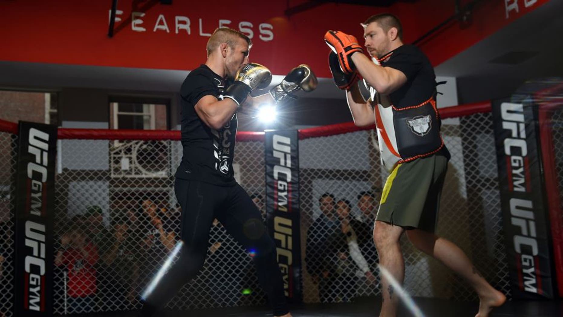 BOSTON, MA - JANUARY 15: UFC bantamweight champion TJ Dillashaw (L) works out with his coach Duane Ludwig (R) for fans and media at the UFC Gym on January 15, 2016 in Boston, Massachusetts. (Photo by Jeff Bottari/Zuffa LLC/Zuffa LLC via Getty Images)
