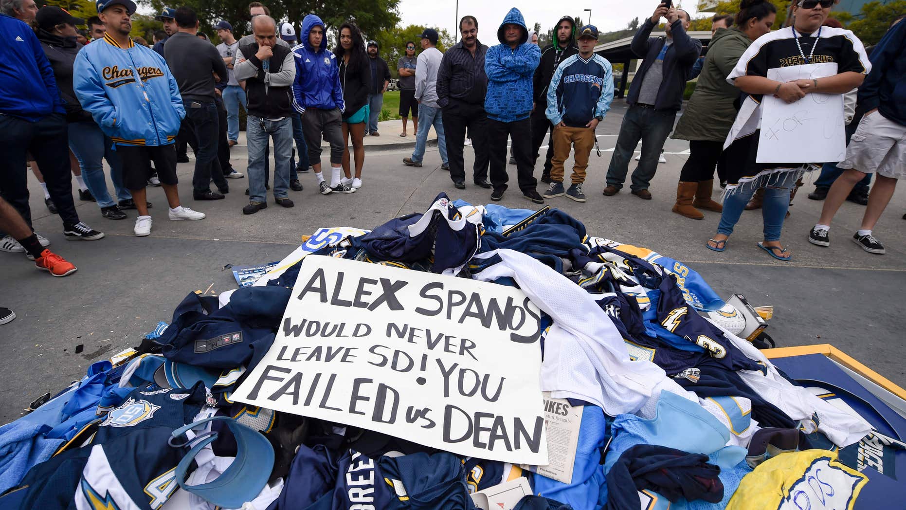 ans stand around a pile of Chargers memorabilia in front of San Diego Chargers headquarters after the team announced that it will move to Los Angeles Thursday Jan. 12, 2017, in San Diego.