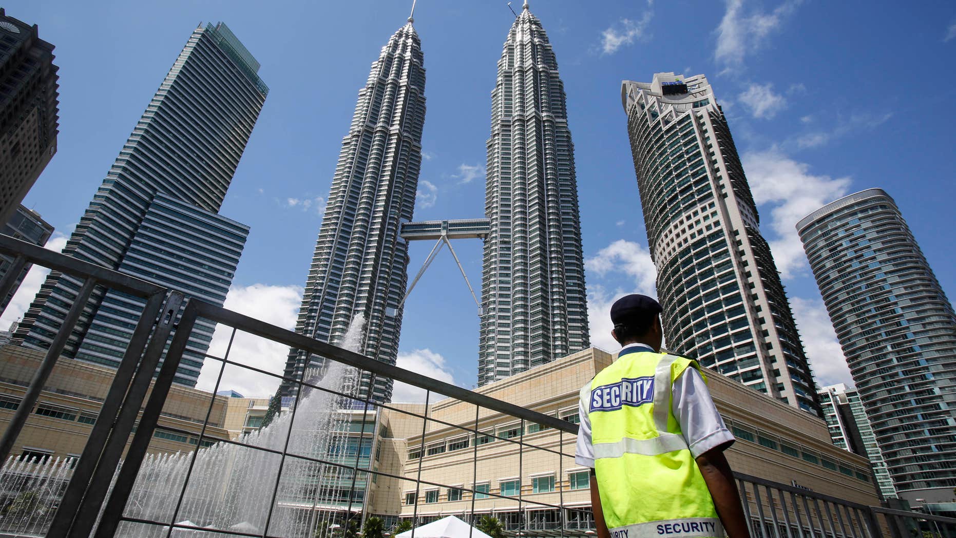 Dec. 31, 2015: A security guard patrols in front of Malaysia's landmark buildings, Petronas Twin Towers, ahead of the New Year's celebration in Kuala Lumpur, Malaysia.