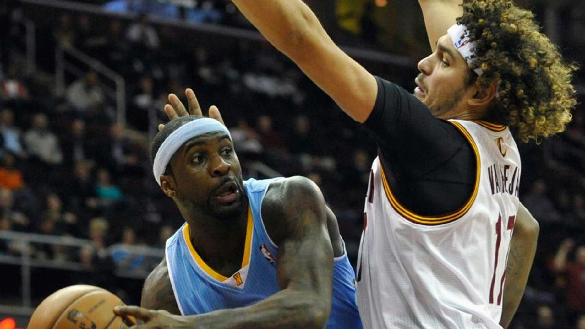 Dec 4, 2013; Cleveland, OH, USA; Denver Nuggets point guard Ty Lawson (3) drives against Cleveland Cavaliers center Anderson Varejao (17) in the first quarter at Quicken Loans Arena. Mandatory Credit: David Richard-USA TODAY Sports