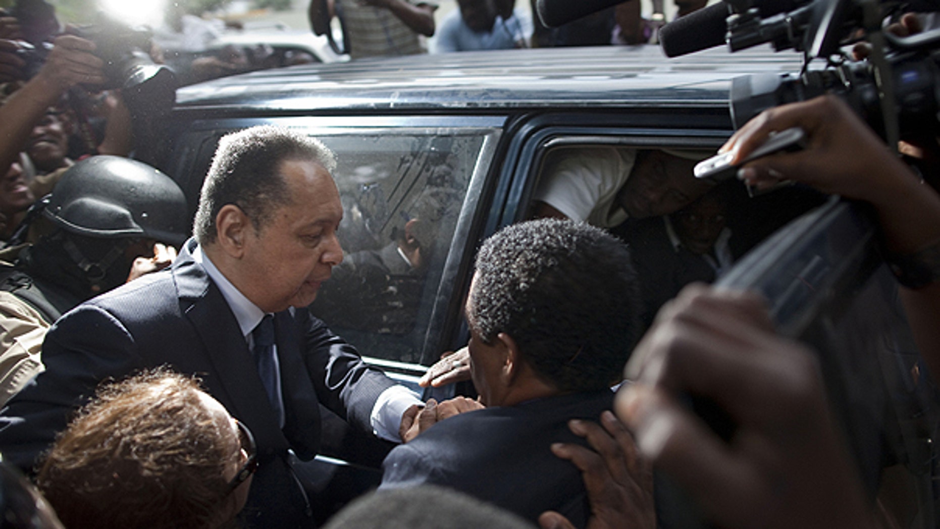 Jan. 18: Haiti's former dictator Jean-Claude Duvalier, left, leaves court surrounded by journalists in Port-au-Prince, Haiti.