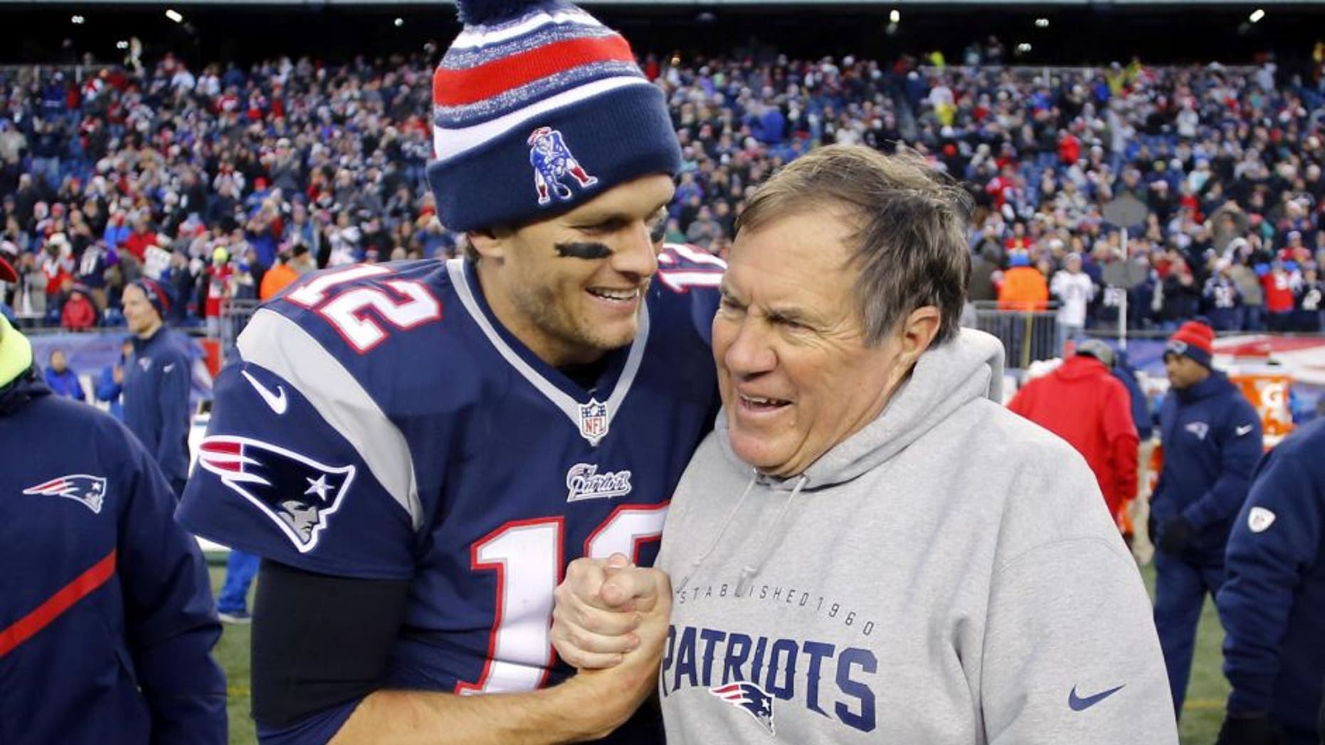 Dec 14, 2014; Foxborough, MA, USA; New England Patriots quarterback Tom Brady (12) celebrates with head coach Bill Belichick (R) after clinching the AFC East title with a 41-13 win over the Miami Dolphins at Gillette Stadium. Mandatory Credit: Winslow Townson-USA TODAY Sports Picture Supplied by Action Images
