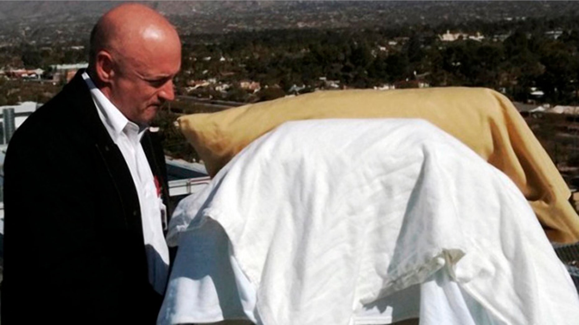 In this photo provided by the office of U.S. Rep Gabrielle Giffords, Giffords' husband, Mark Kelly, stands with his wife as she looks from her bed at the Santa Catalina Mountains while on an outdoor deck at University Medical Center in Tucson, Ariz., Thursday, Jan. 20, 2011. Giffords is scheduled to be flown to Houston on Friday to begin her rehabilitation. (AP Photo/Office of U.S. Rep. Gabrielle Giffords)
