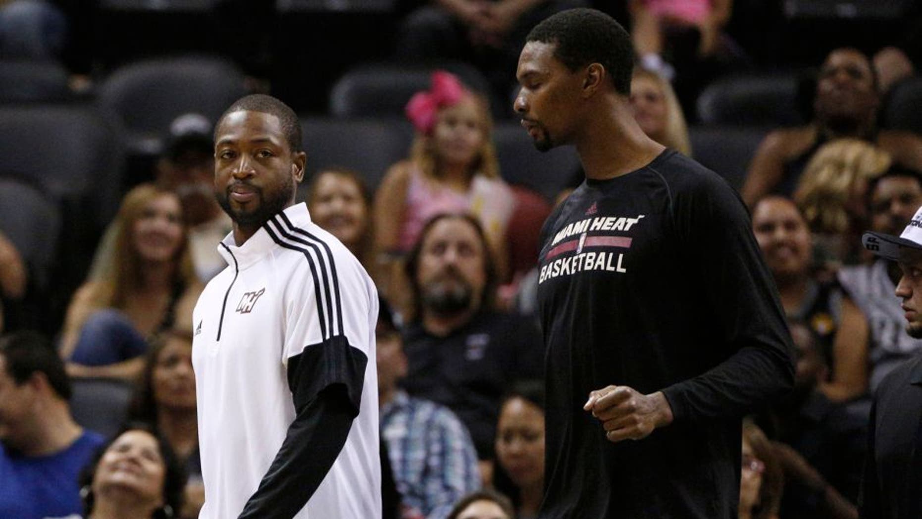 Oct 18, 2014; San Antonio, TX, USA; Miami Heat shooting guard Dwyane Wade (3) and power forward Chris Bosh (1) walk onto the court during the second half against the San Antonio Spurs at AT&T Center. The Heat won 111-108 in overtime. Mandatory Credit: Soobum Im-USA TODAY Sports