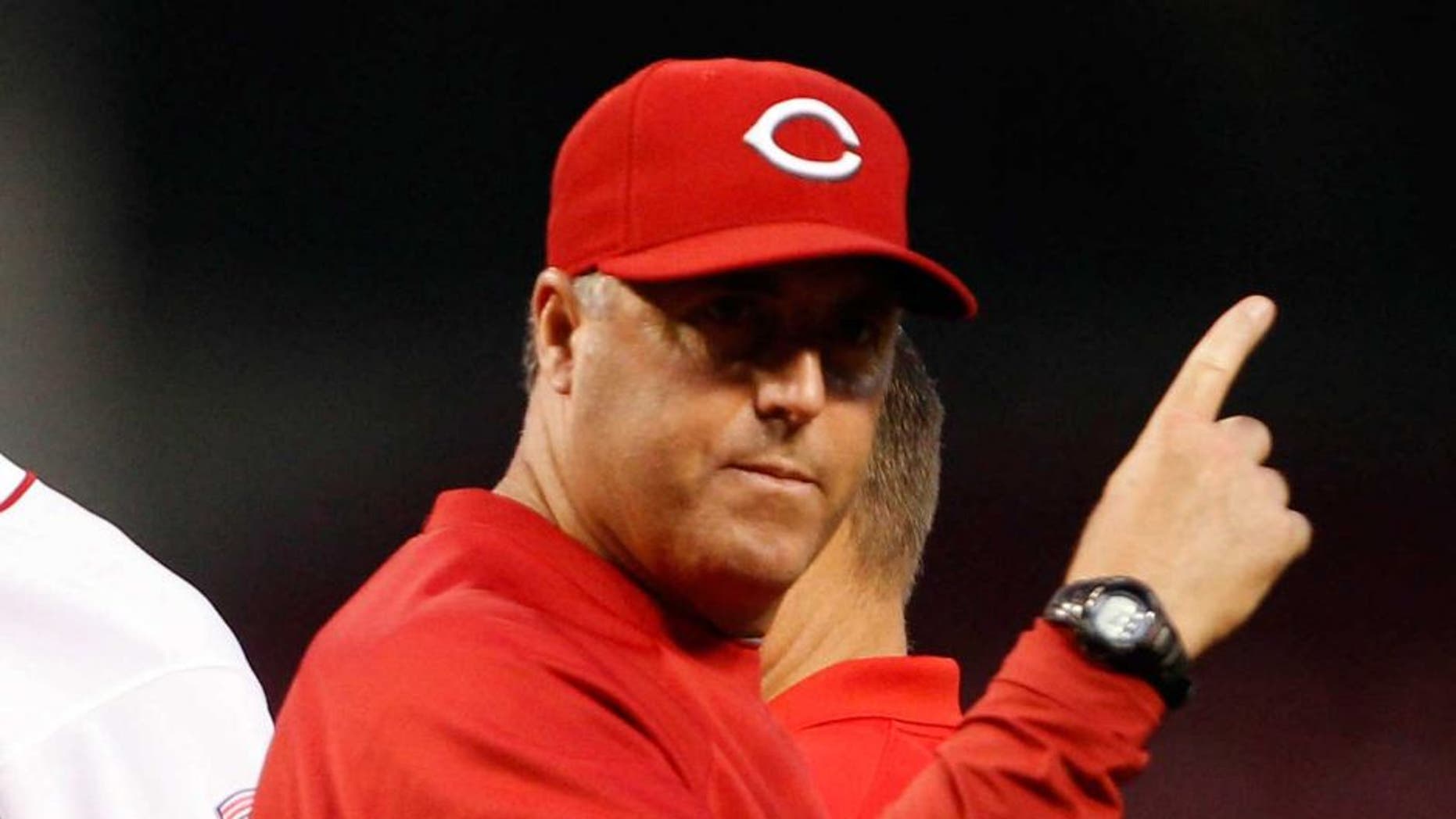 Sep 10, 2013; Cincinnati, OH, USA; Cincinnati Reds pitching coach Bryan Price (right) signals for a relief pitcher during the second after starting pitcher Tony Cingrani (52) leaves the game injured against the Chicago Cubs at Great American Ball Park. Mandatory Credit: Frank Victores-USA TODAY Sports