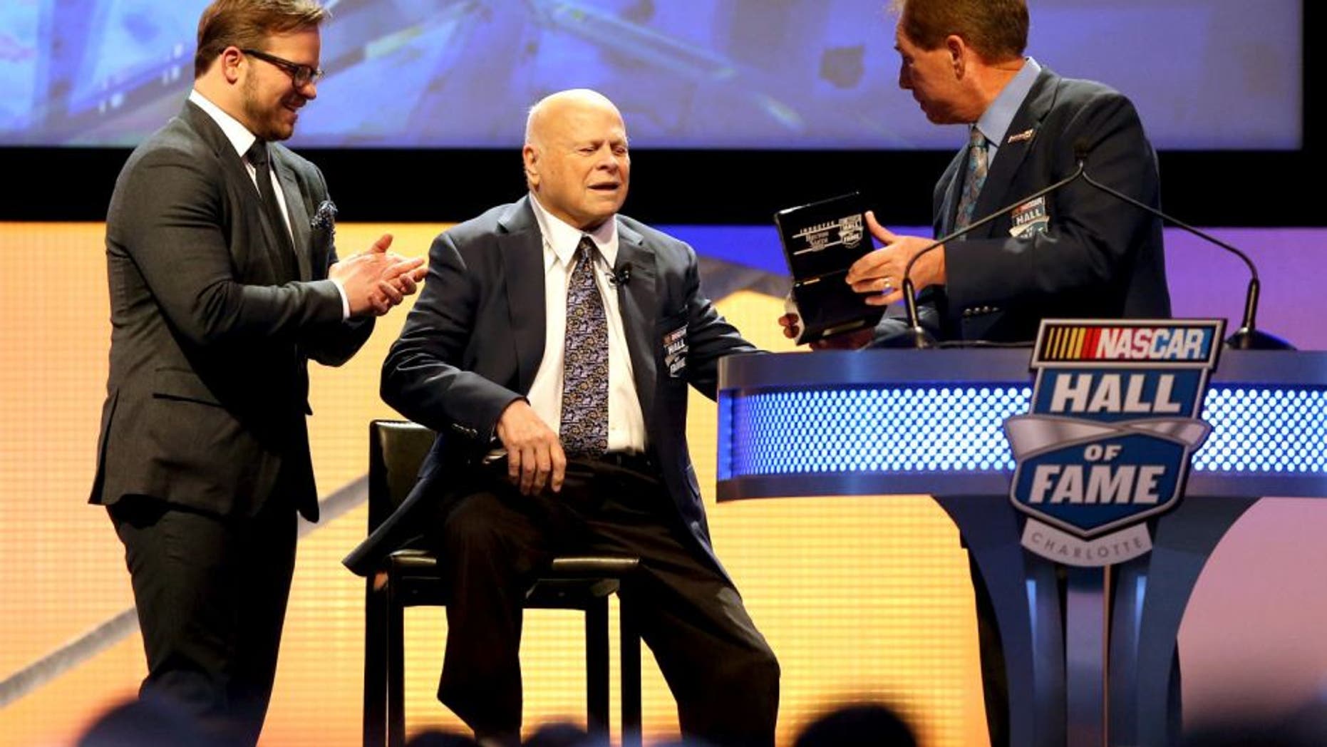 CHARLOTTE, NC - JANUARY 23: (L-R) Marcus Smith watches as his father, Bruton Smith, is inducted into the NASCAR Hall of Fame by Darrell Waltrip during the NASCAR Hall of Fame Induction Ceremony on January 23, 2016 in Charlotte, North Carolina. (Photo by Streeter Lecka/NASCAR via Getty Images)
