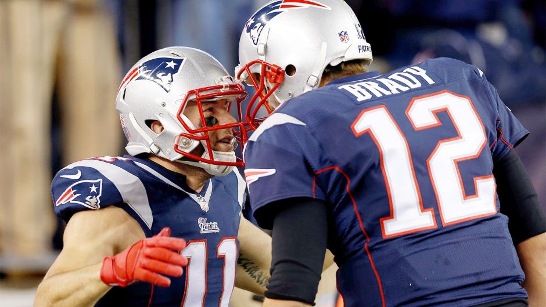 Nov 2, 2014; Foxborough, MA, USA; New England Patriots quarterback Tom Brady (12) congratulates special teams Julian Edelman (11) on scoring a touchdown on a run back return during the second quarter against the Denver Broncos at Gillette Stadium. Mandatory Credit: Greg M. Cooper-USA TODAY Sports